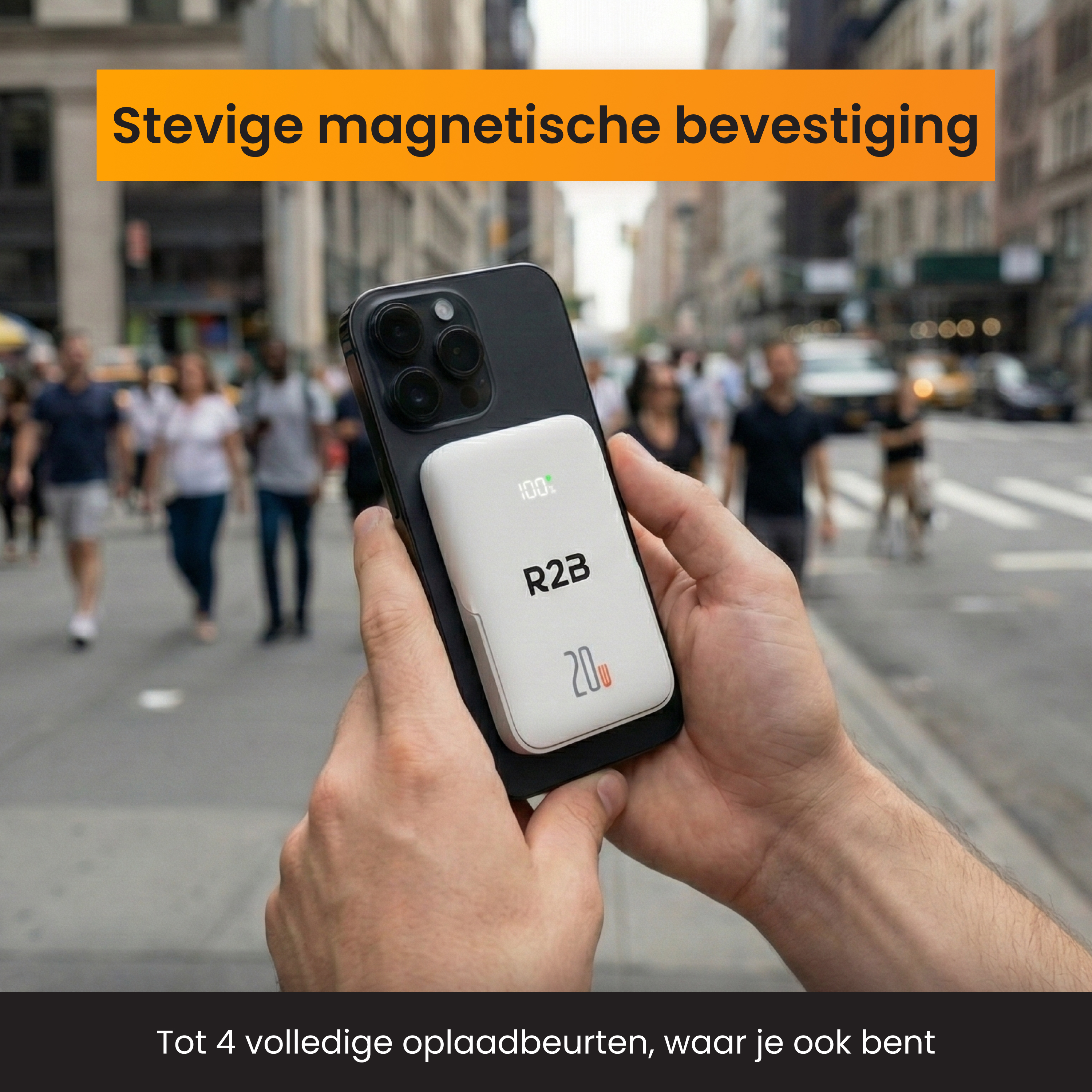 A person holds a white R2B charger to a smartphone on a busy street.