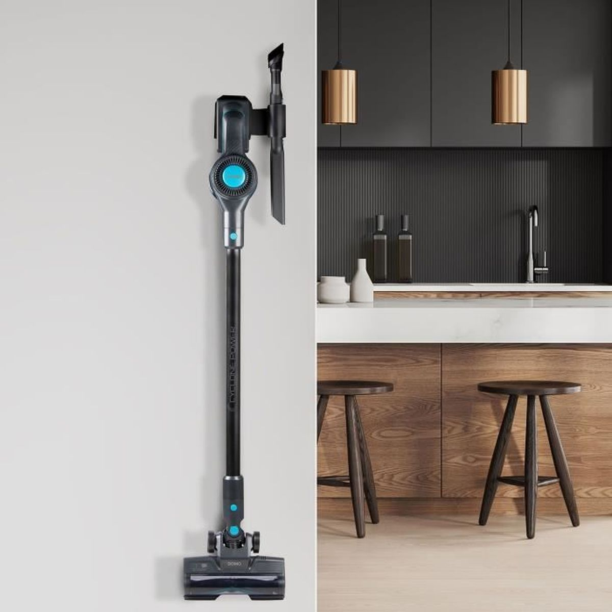 Un aspirapolvere senza fili con accenti blu è appeso a una parete accanto a una cucina moderna.