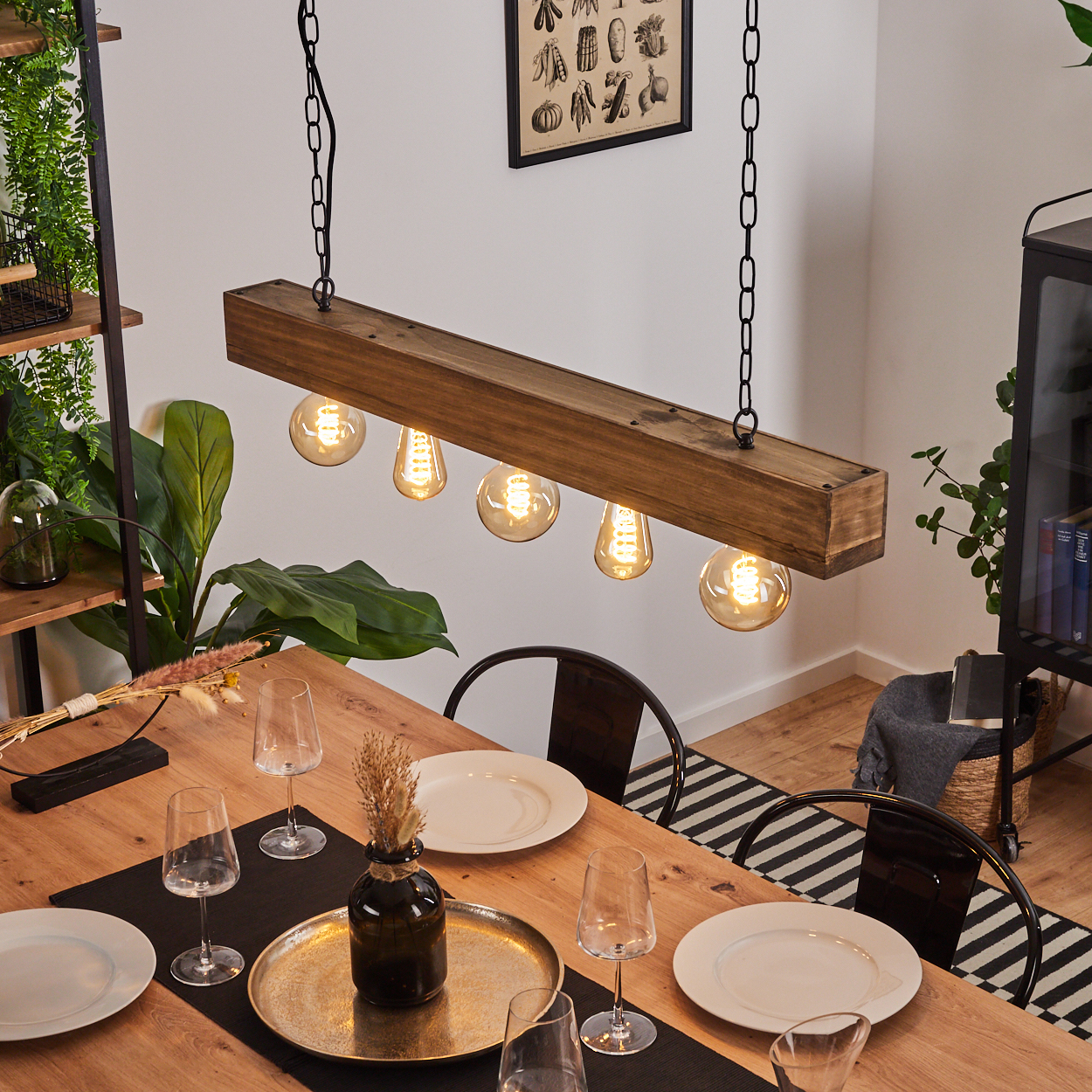 Holzpendelleuchte mit fünf Glühbirnen über einem Holztisch mit Geschirr.