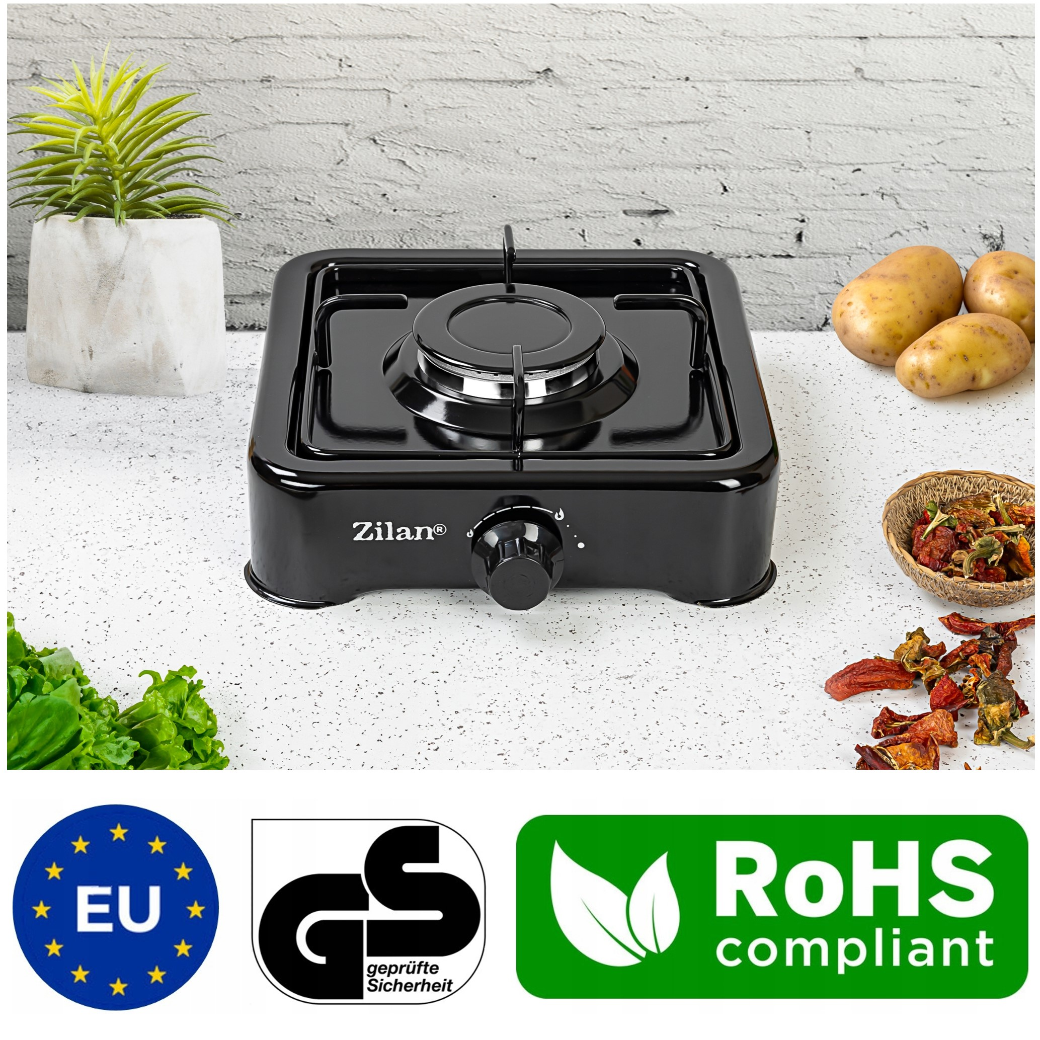 Czarna kuchenka gazowa z ziemniakami, sałatą, suszonymi papryczkami chili i certyfikatami.