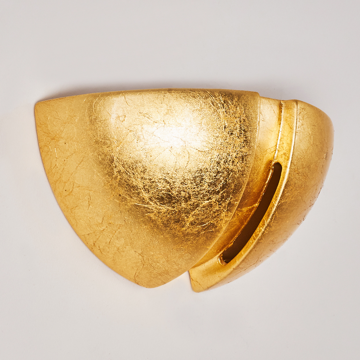 Eine goldene Wandleuchte mit einer strukturierten Oberfläche.
