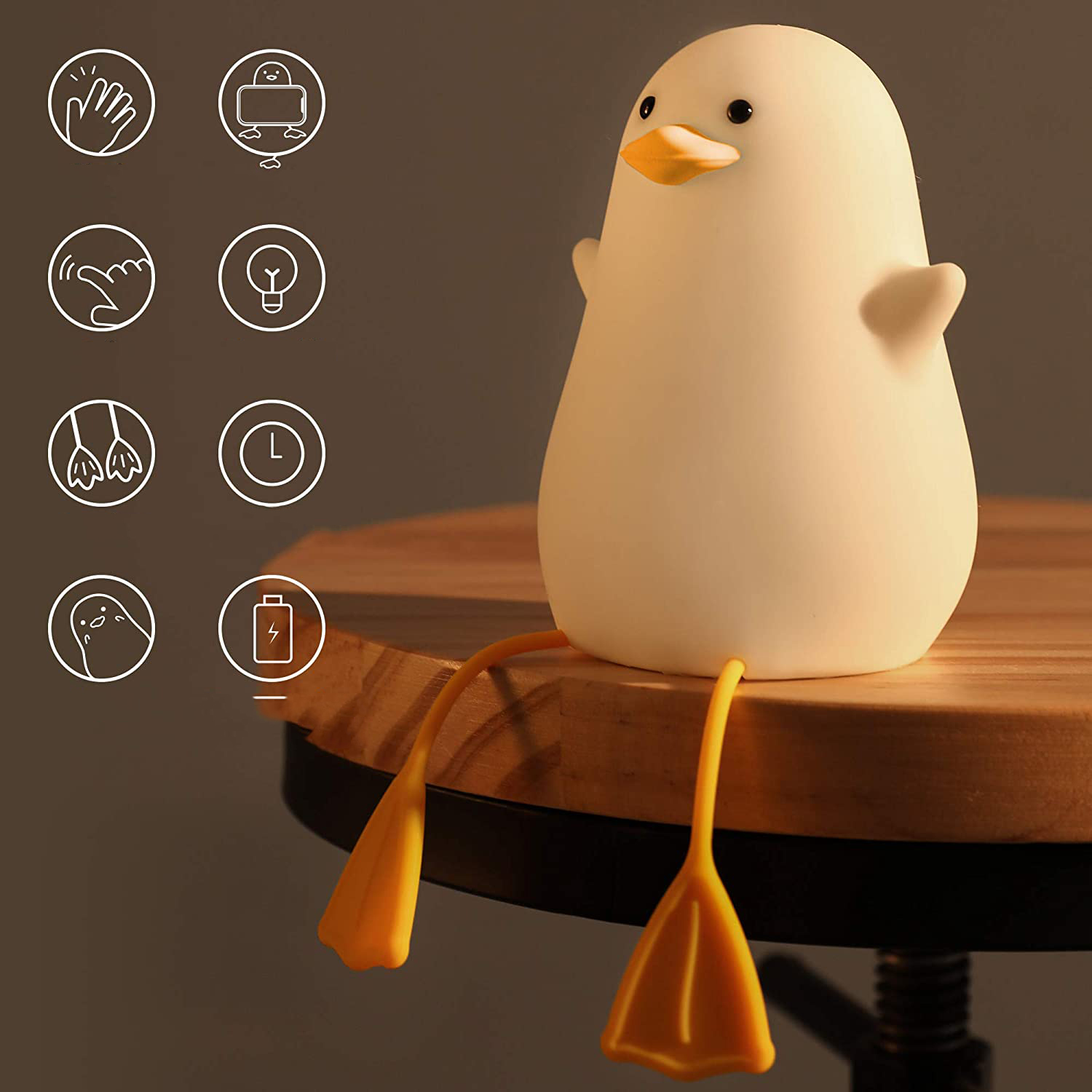 Eine weiße Ente Lampe mit gelben Füßen sitzt auf einem Holztisch.