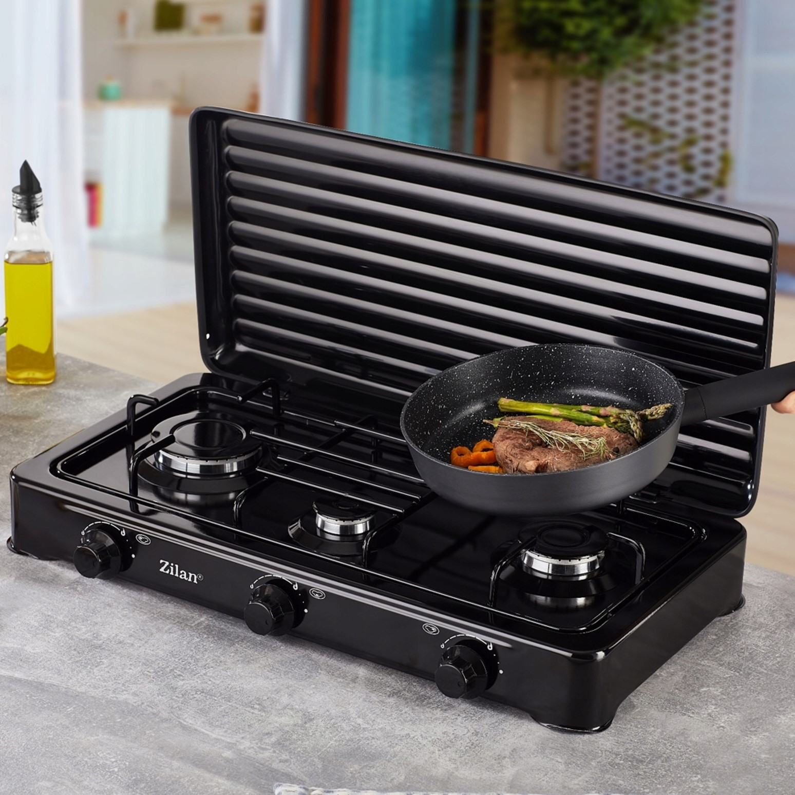 Stek z szparagami i marchewką smaży się na patelni na czarnej kuchence gazowej.