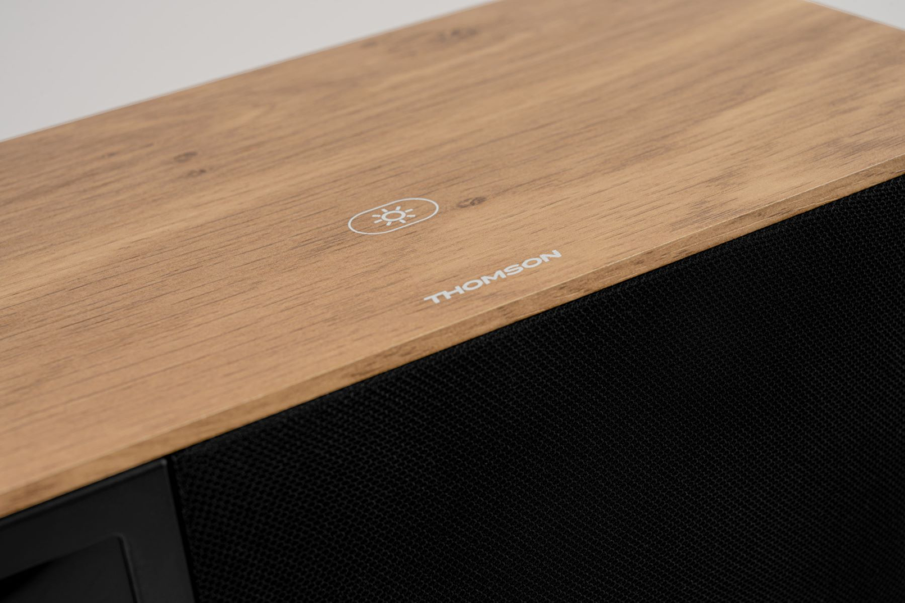 Drewniany głośnik z czarną kratką, logo THOMSON i ikoną słońca.