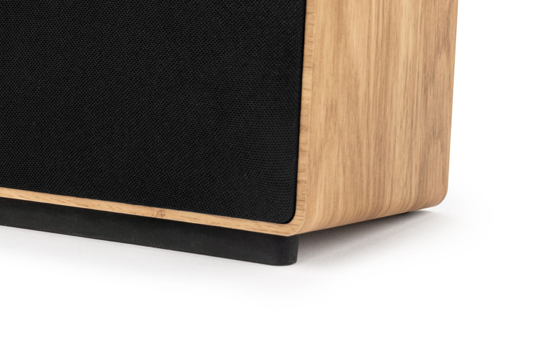 Zbliżenie głośnika z czarną kratką materiałową i drewnianą obudową.