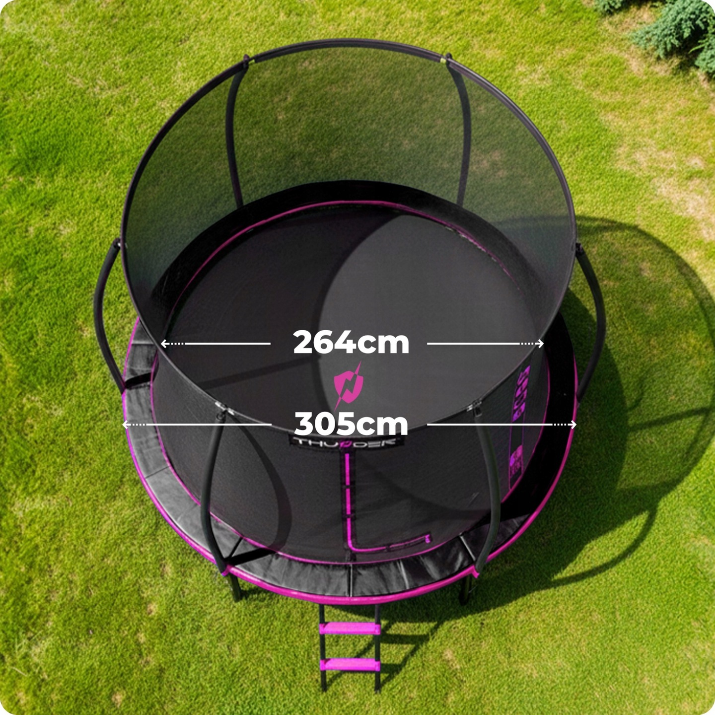 Czarna trampolina z różowym wykończeniem i siatką ochronną na zielonej trawie.