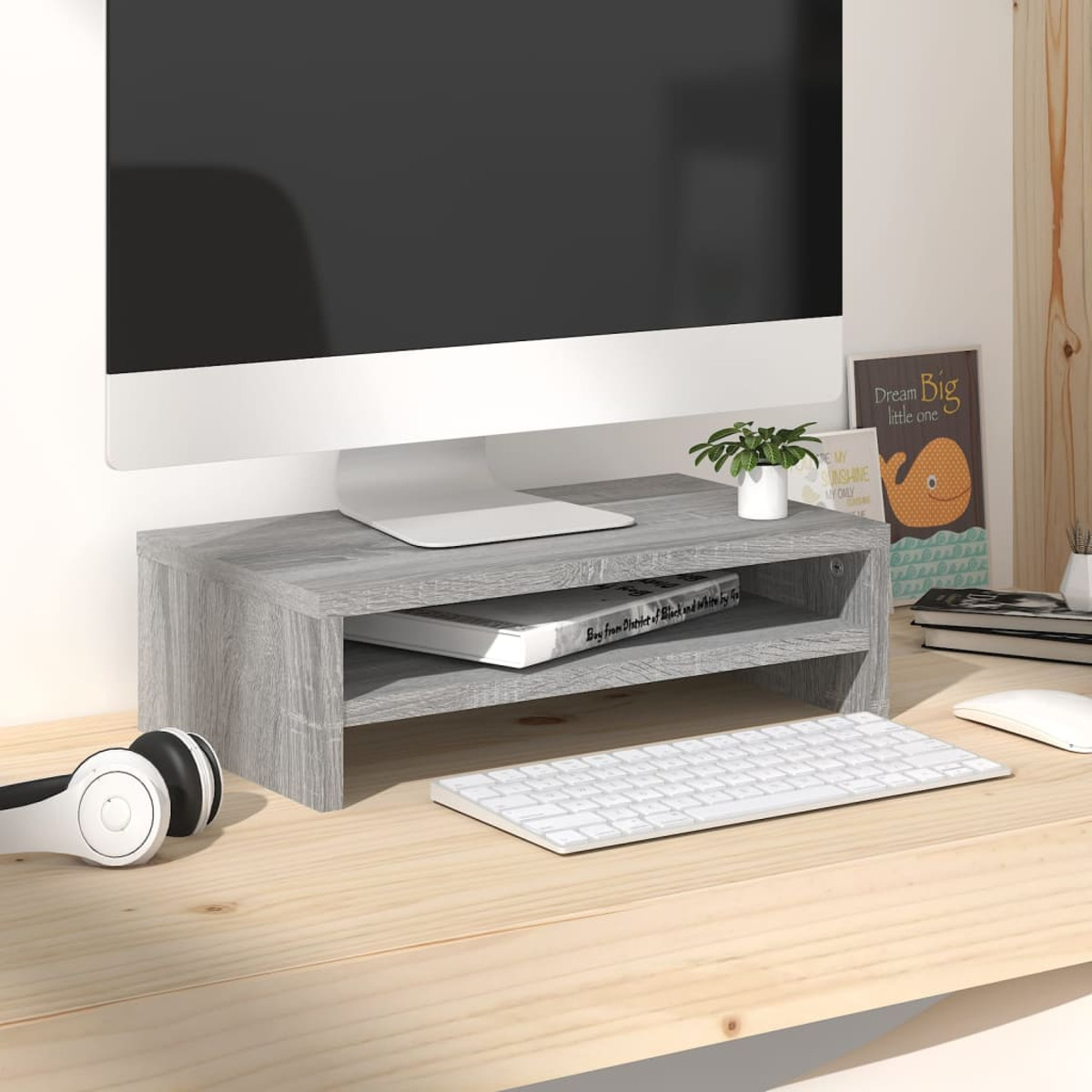Un escritorio con un soporte para monitor, teclado, ratón y auriculares.