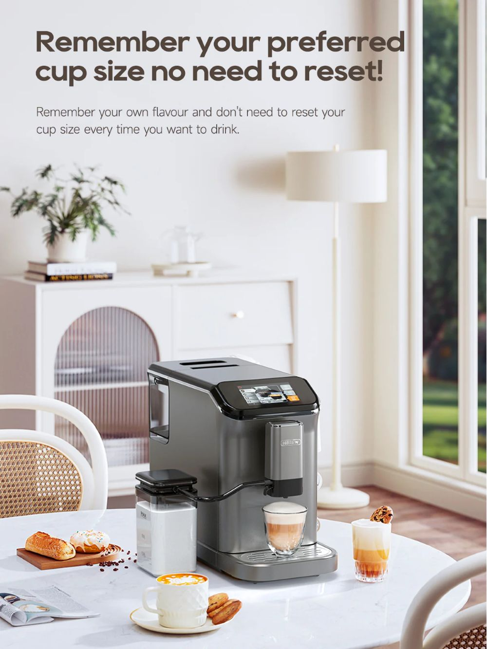 Una cafetera moderna con café y pasteles sobre una mesa.