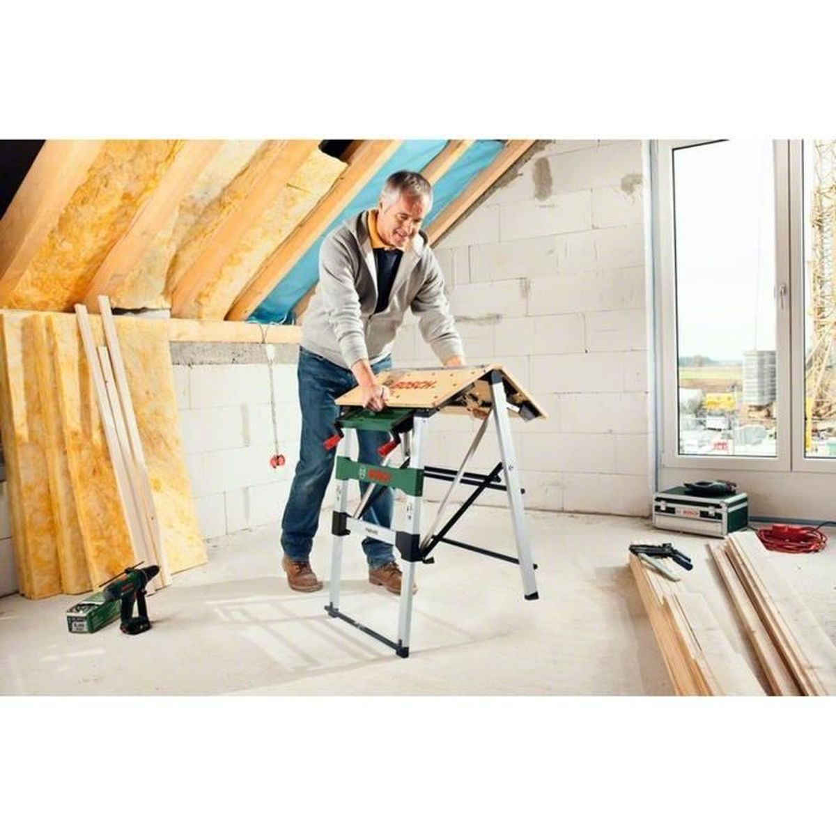 Mann arbeitet an Werkbank mit Holz und Werkzeug.