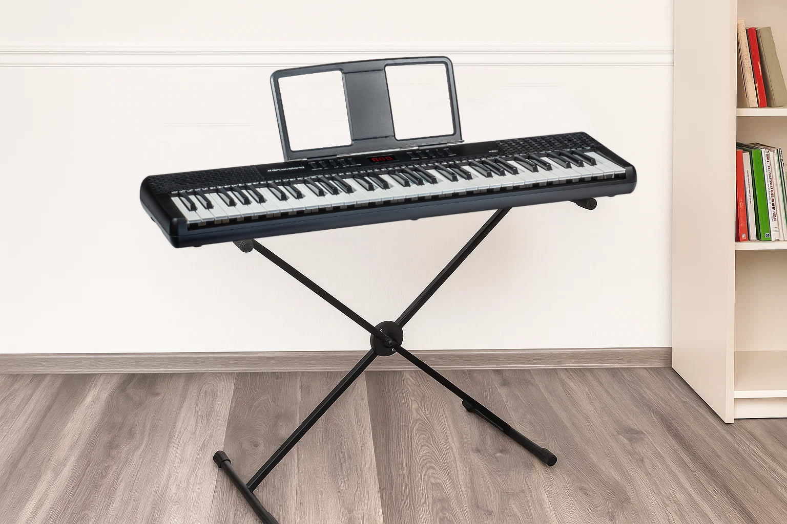 Ein schwarzes Keyboard steht auf einem schwarzen X-Ständer vor einer weißen Wand.