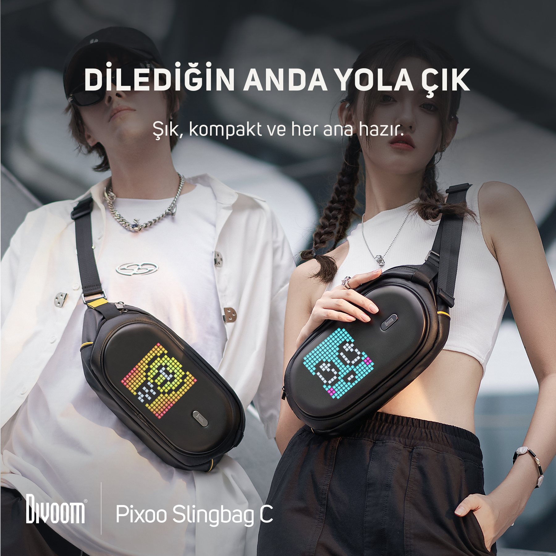 İki kişi, piksel ekranlı siyah çapraz askılı çanta takıyor. Bir erkek ve bir kadın.