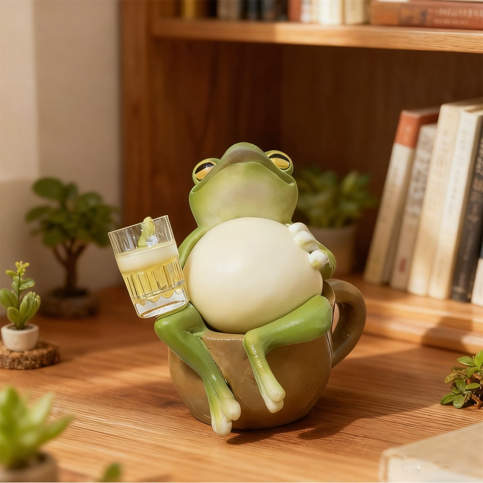 Eine grüne Figur eines Frosches sitzt in einer braunen Tasse und hält ein Glas Bier.