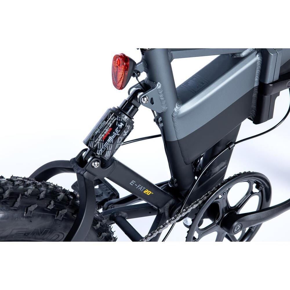 Primo piano di una e-bike grigia con sospensioni e catena.