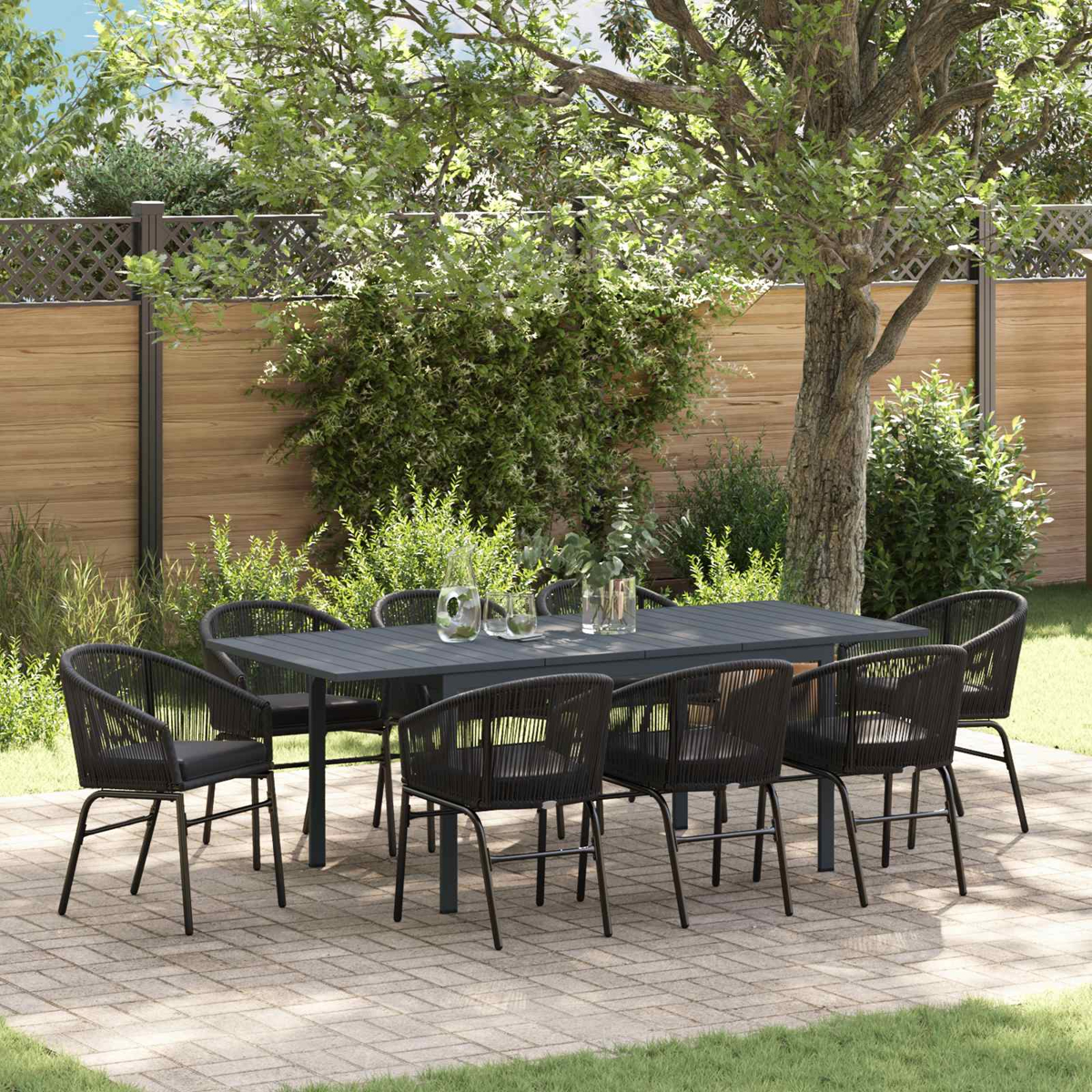 Un juego de comedor exterior con ocho sillas y una mesa en un patio de ladrillos, rodeado de vegetación.