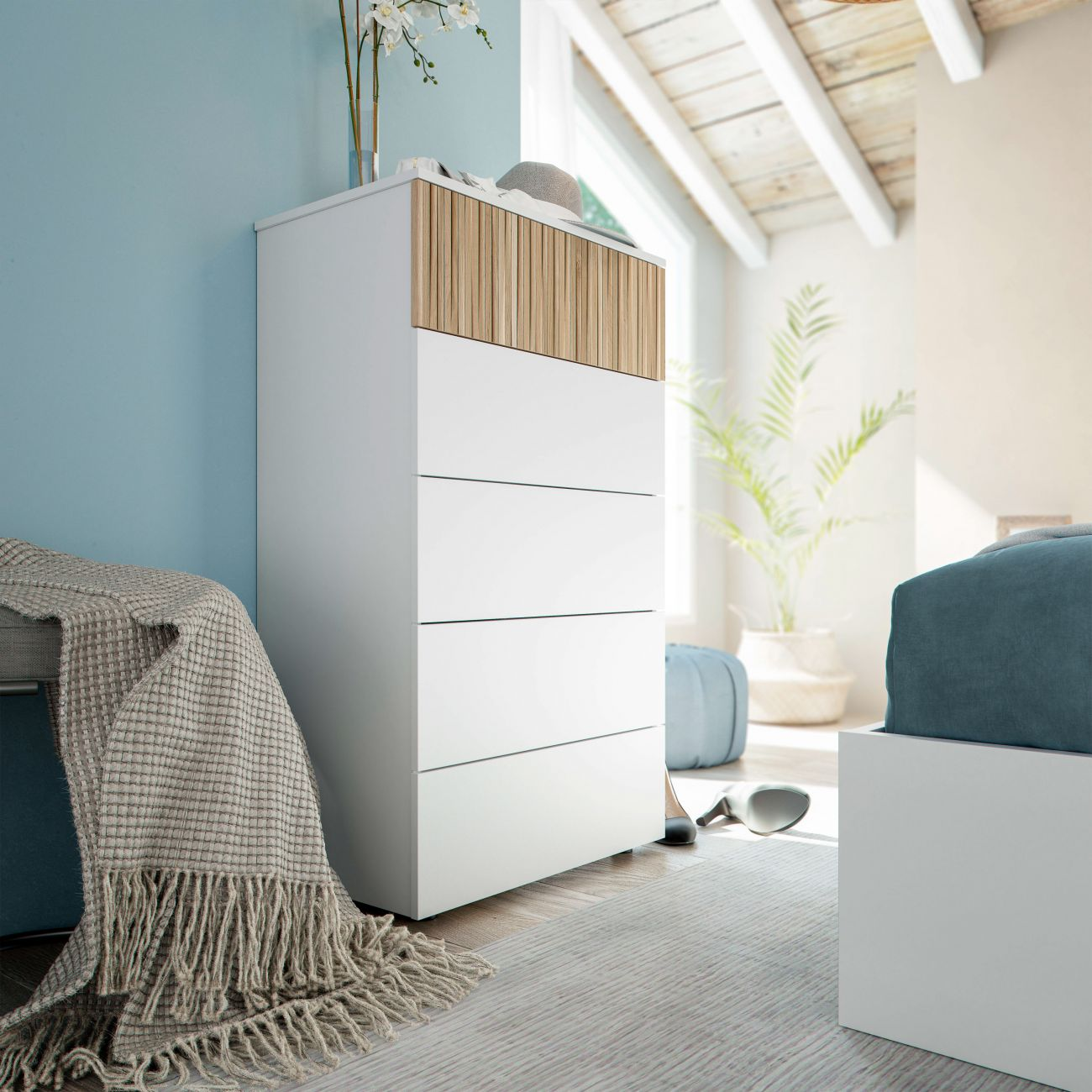 Cómoda blanca con tapa de madera junto a pared y techo azules.
