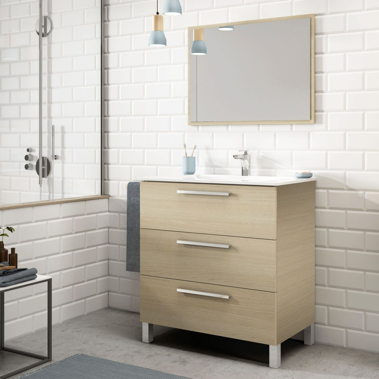 Baño moderno con tocador de madera clara, azulejos blancos tipo metro y ducha.