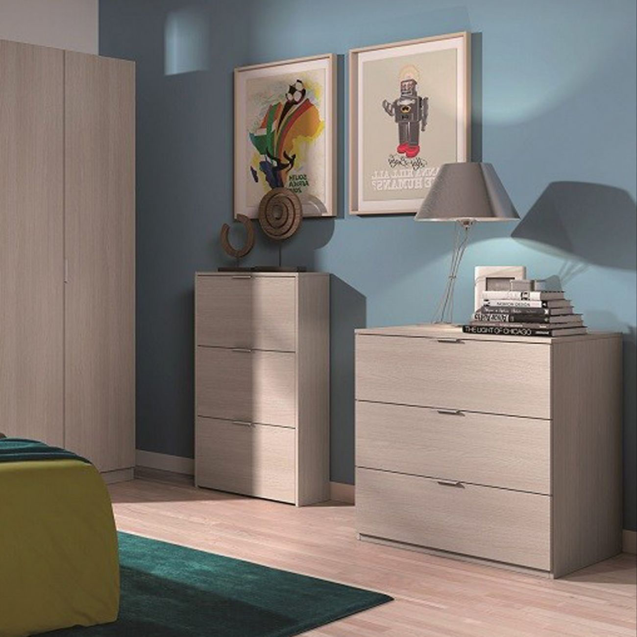 Un dormitorio con muebles de madera clara, pared azul, lámpara y cuadros.