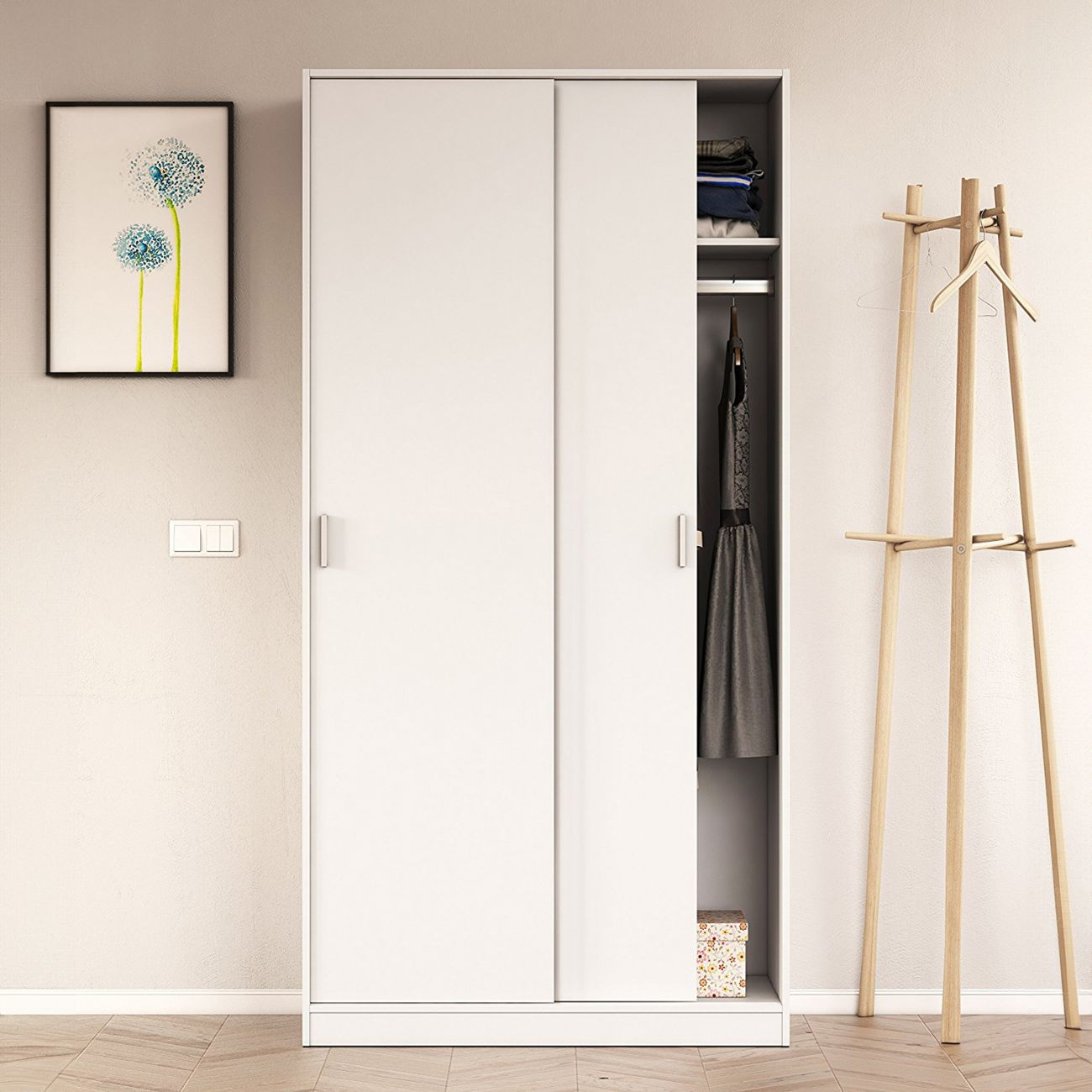 Un armario blanco con puertas abiertas muestra ropa y un pequeño compartimento. Un perchero al lado.