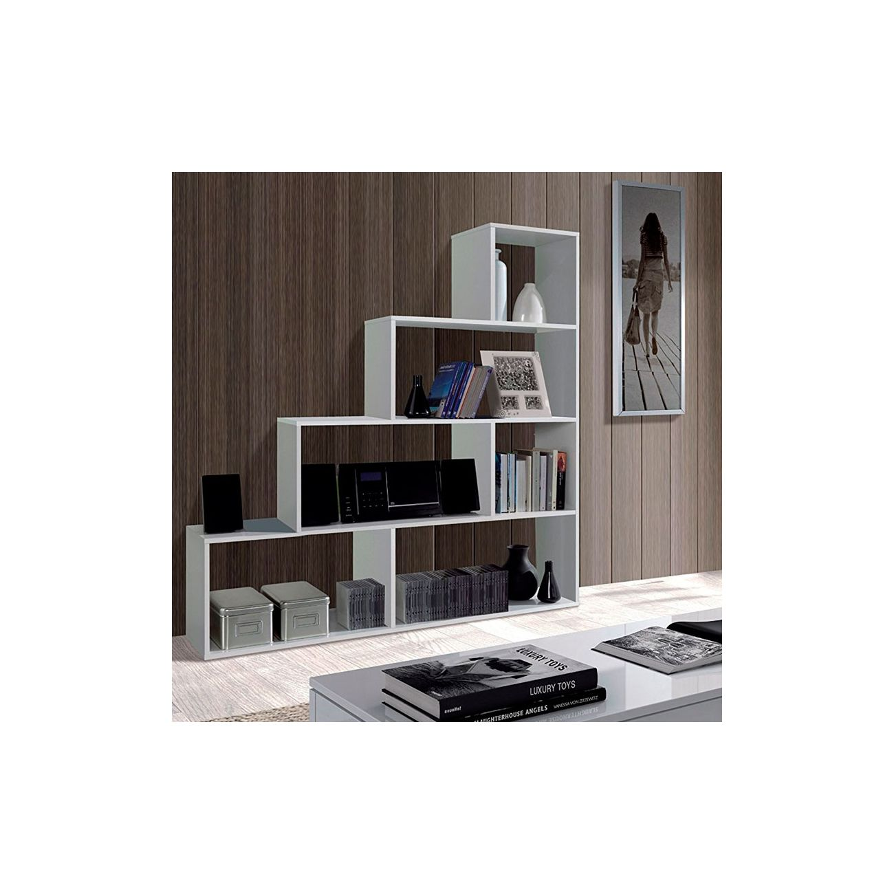Una estantería blanca con libros, cajas y decoración contra pared de madera.