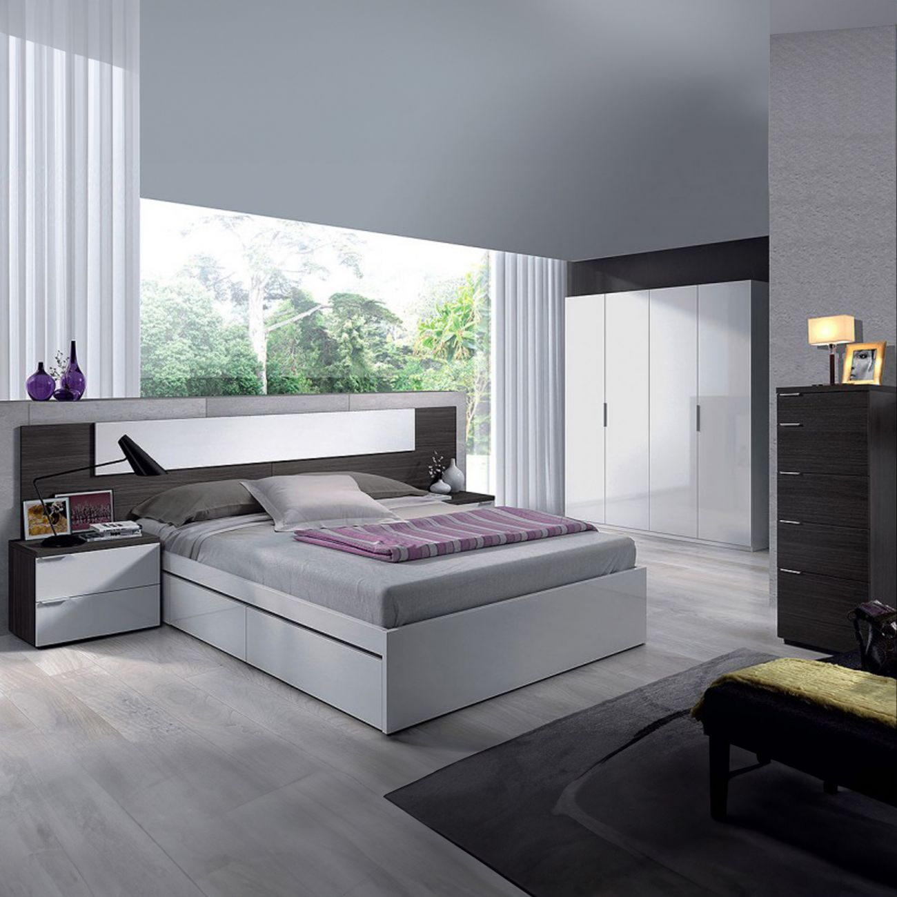 Dormitorio moderno con gran ventana con vistas a árboles. Cama blanca, cómoda oscura, armario blanco.
