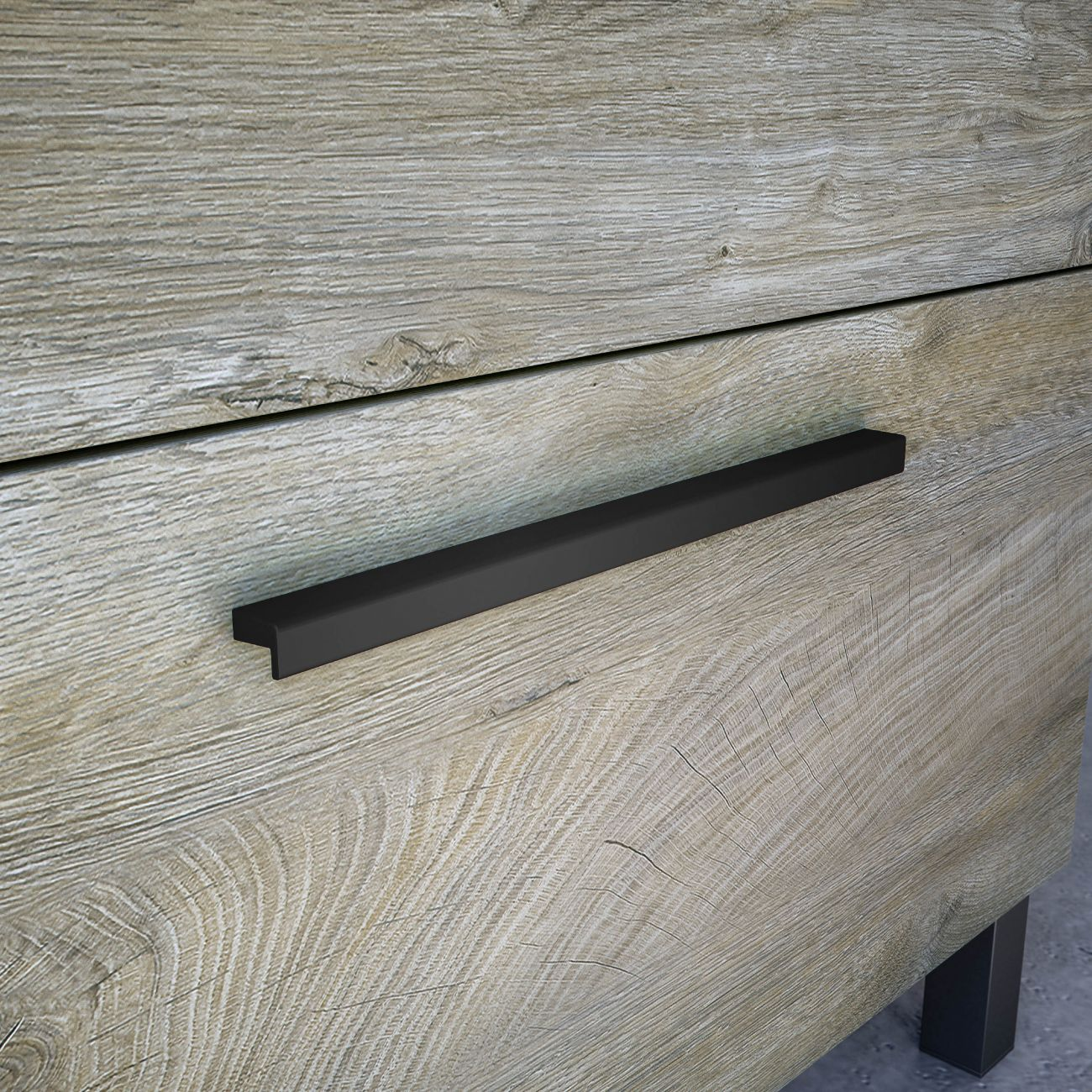 Un tirador negro en un tocador con veta de madera.