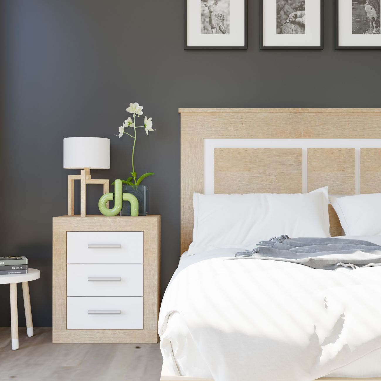 Una mesita de noche con cajones junto a una cama con ropa de cama blanca.