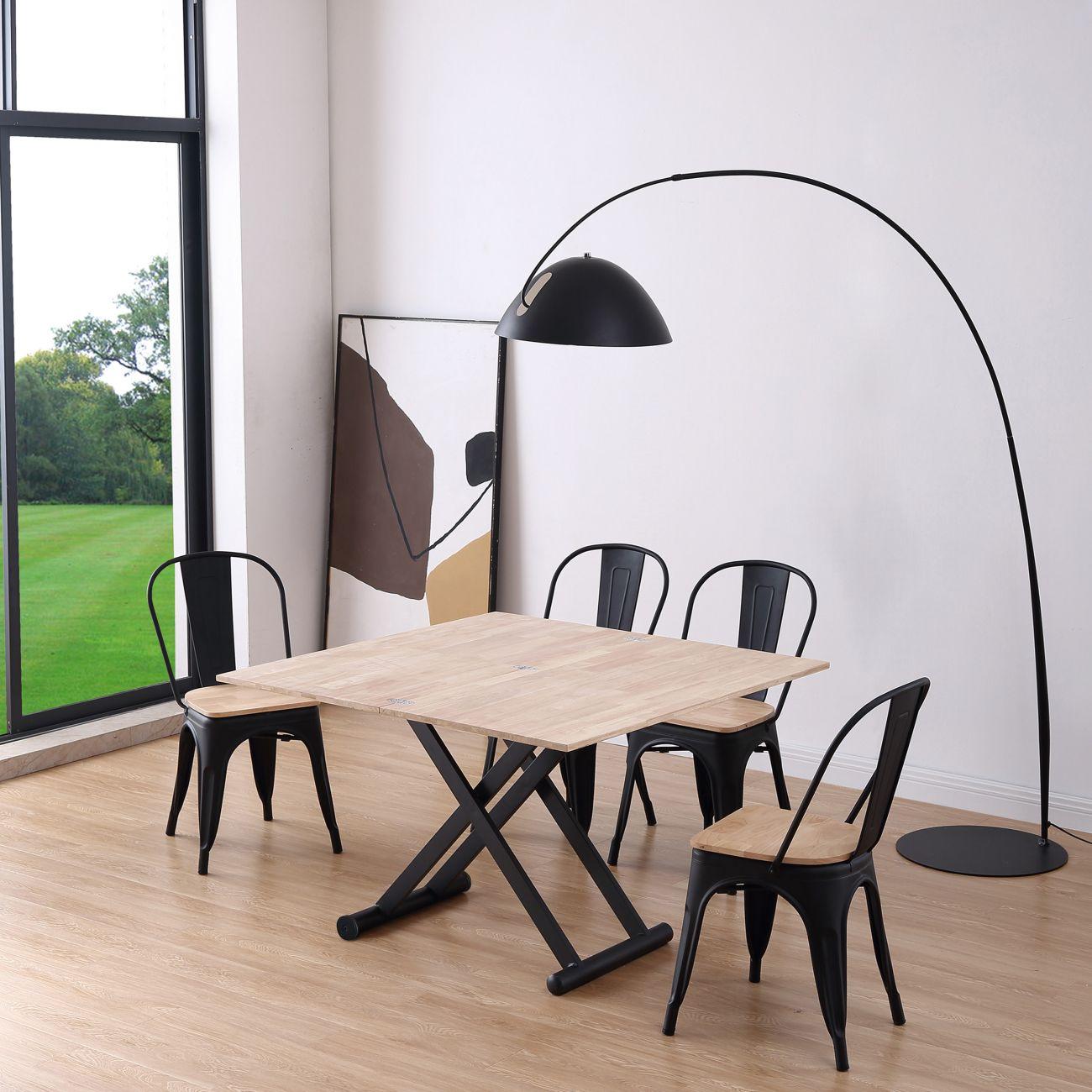 Mesa de madera con cuatro sillas negras en una habitación luminosa.