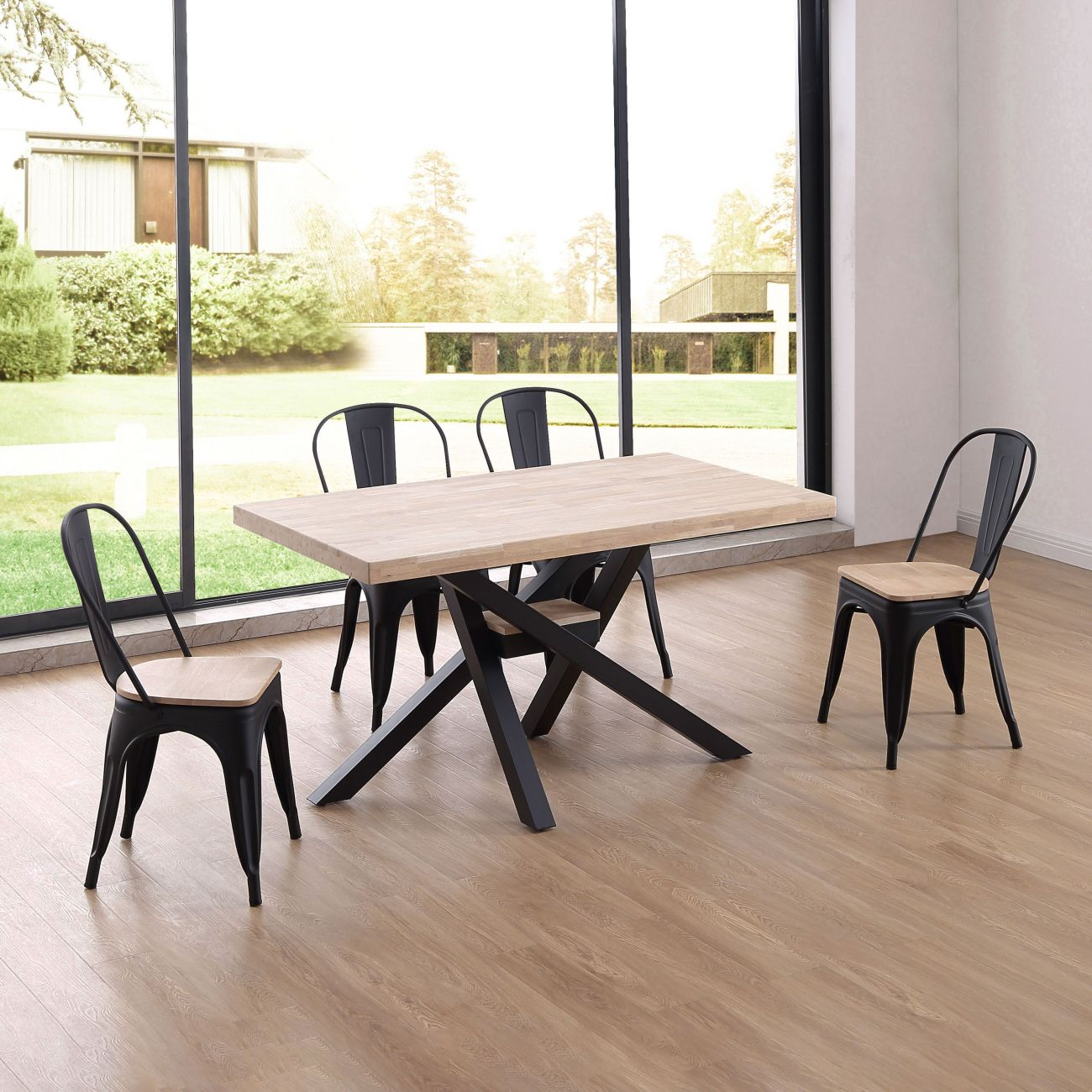 Una mesa de comedor de madera con sillas negras frente a una gran ventana.