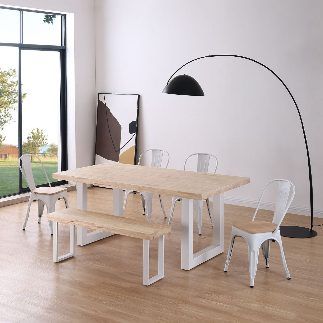 Comedor con mesa de madera, sillas y banco blancos, ventana grande.