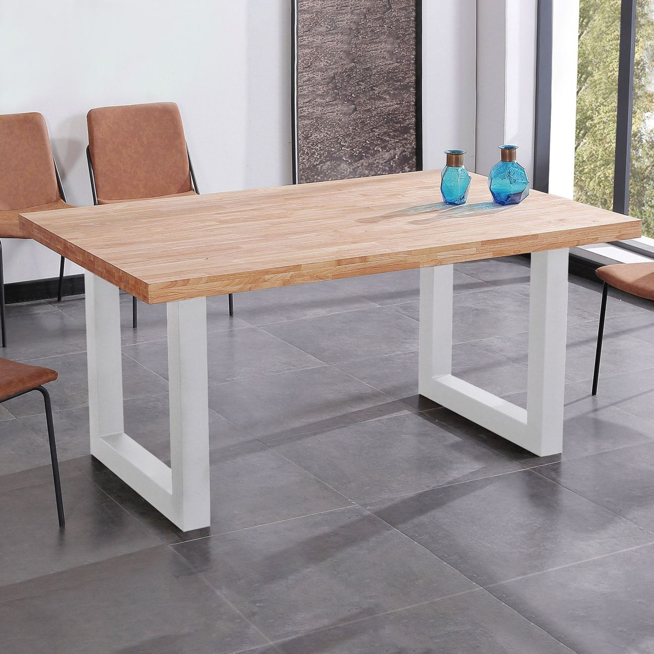 Una mesa de madera con patas blancas sobre suelo de baldosas, dos jarrones azules encima.