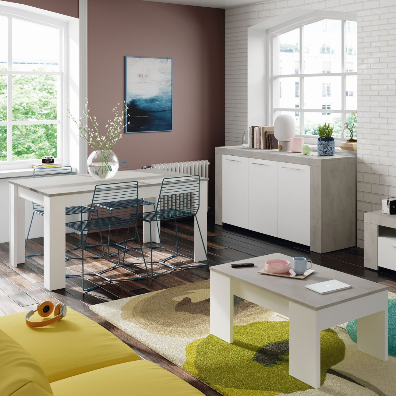 Moderna zona de comedor y sala con sofá amarillo, alfombras y mesa blanca.