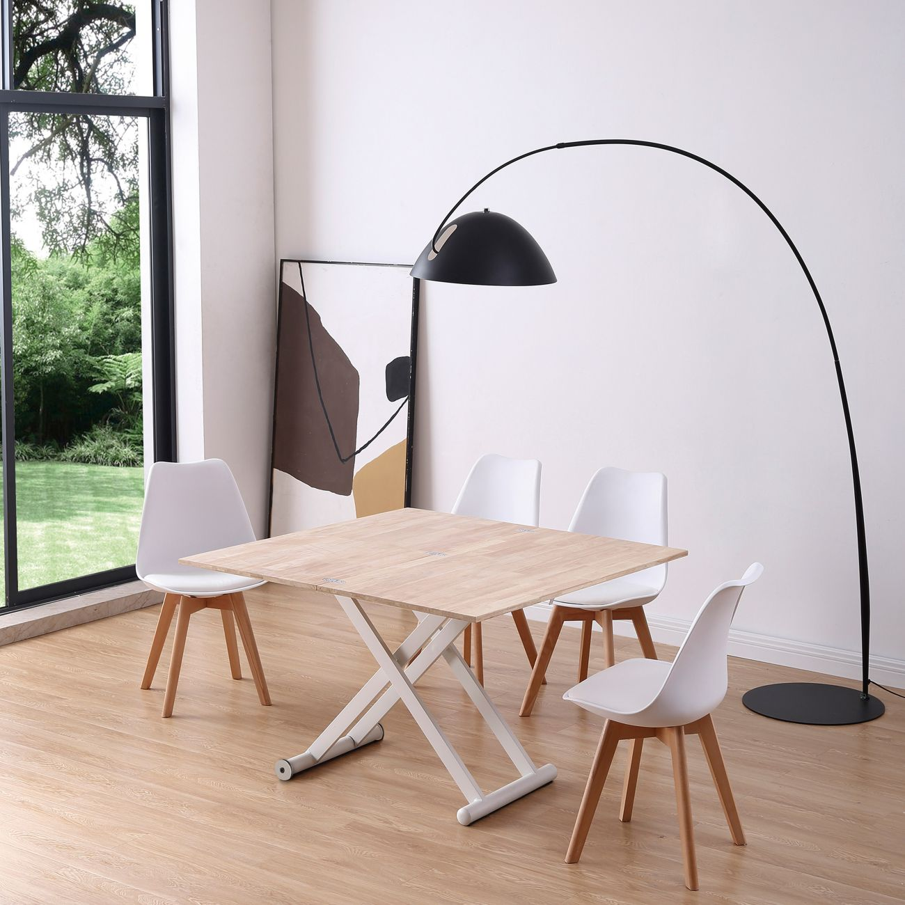 Un comedor luminoso con mesa de madera, cuatro sillas blancas y una lámpara de arco.