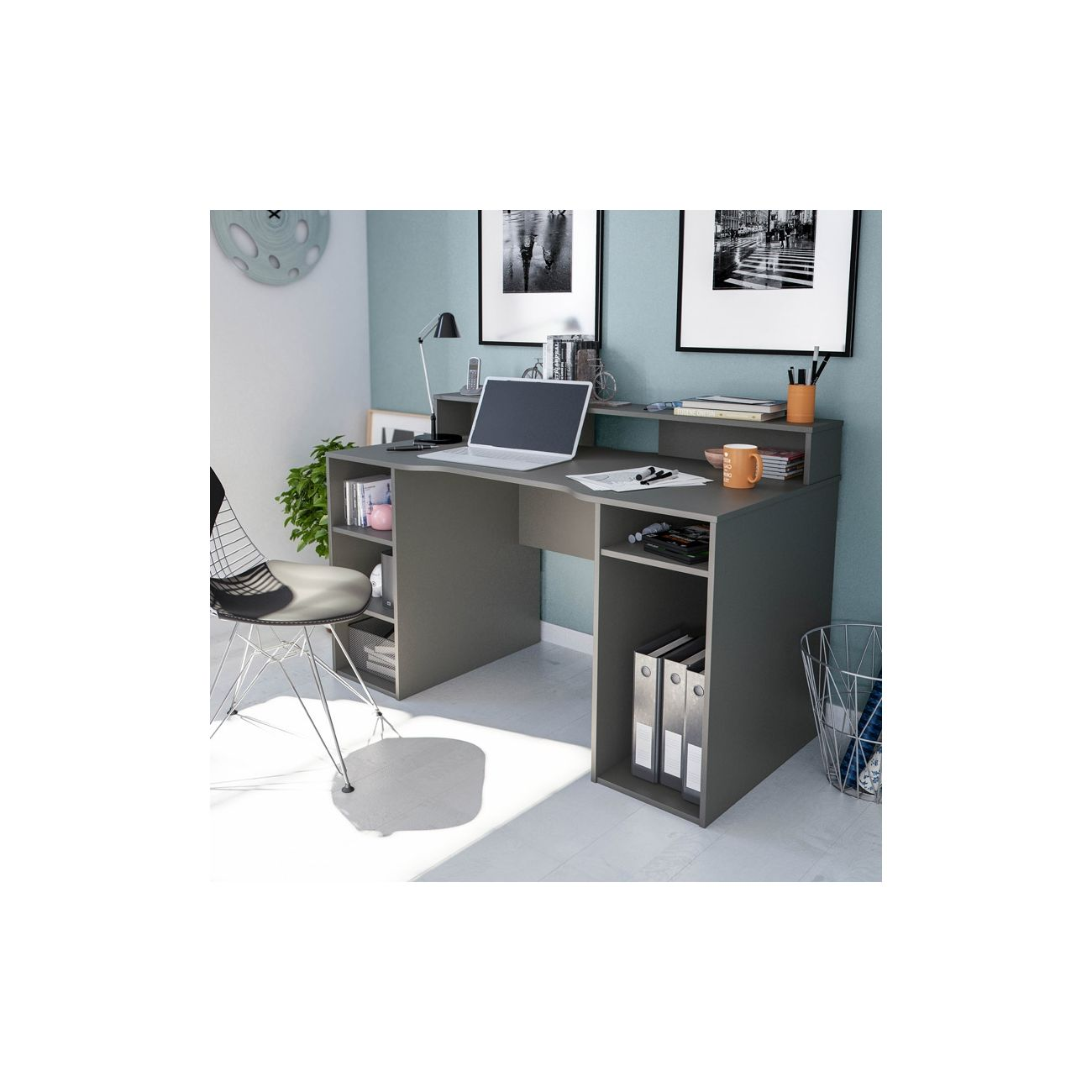 Escritorio gris con portátil, lámpara y material de oficina. Una silla está al lado.