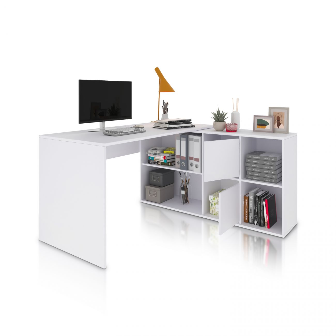 Un escritorio de esquina blanco con monitor, teclado, lámpara y libros.