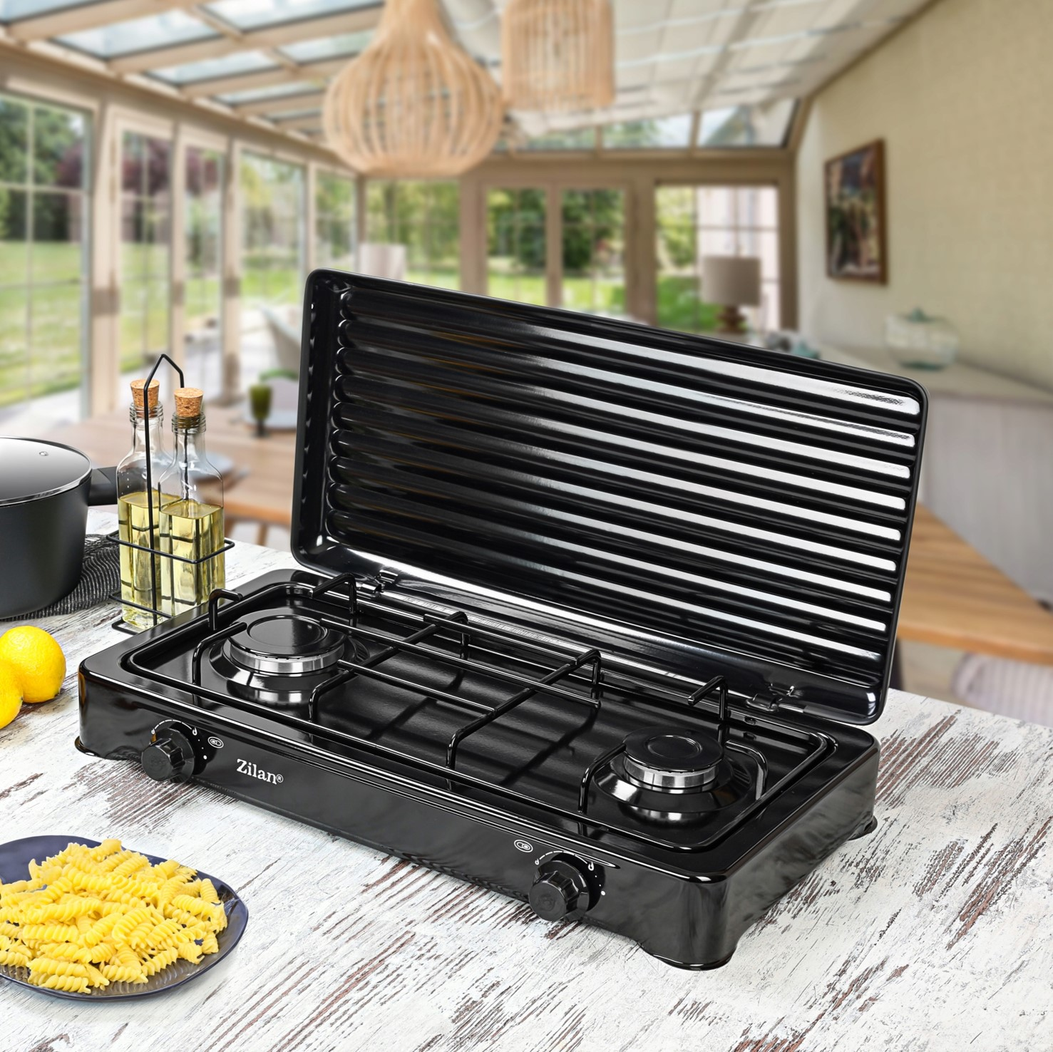 Czarna kuchenka gazowa dwupalnikowa z otwartą pokrywą grillową.