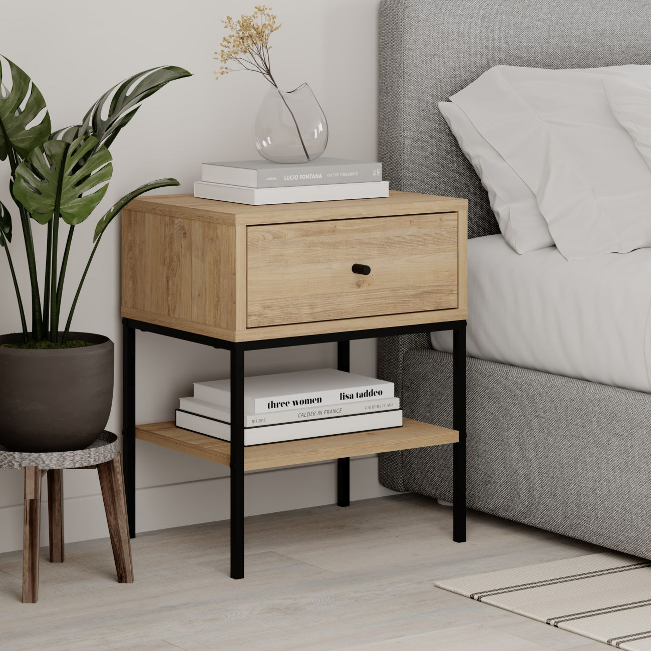 Mesita de noche de madera con estructura de metal negro junto a una cama.