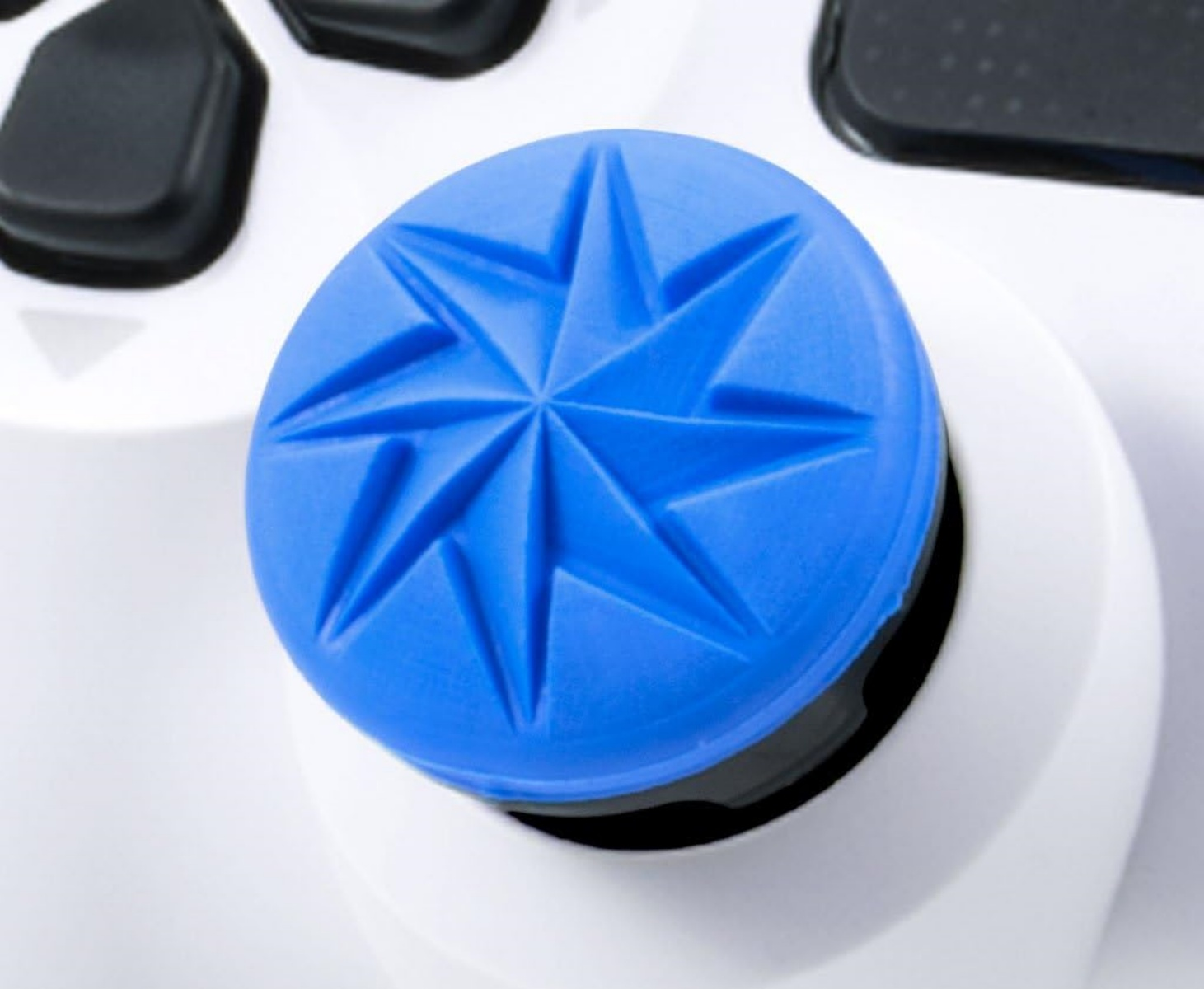 Ein blauer Joystick-Aufsatz mit Sternmuster auf einem weißen Controller.