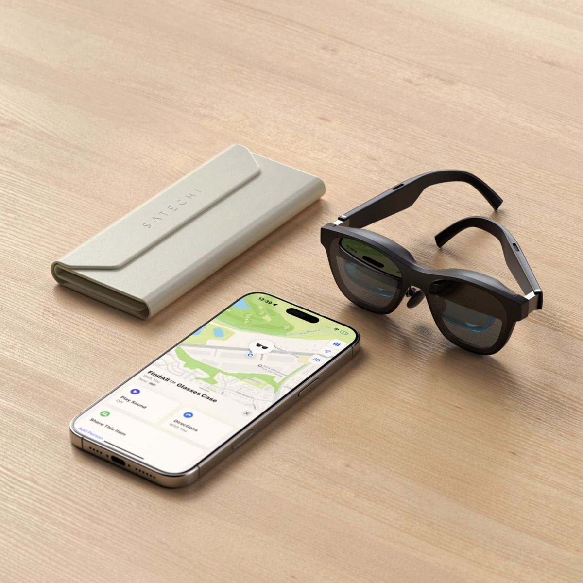 Occhiali neri, custodia grigia e iPhone con mappa su tavolo legno.