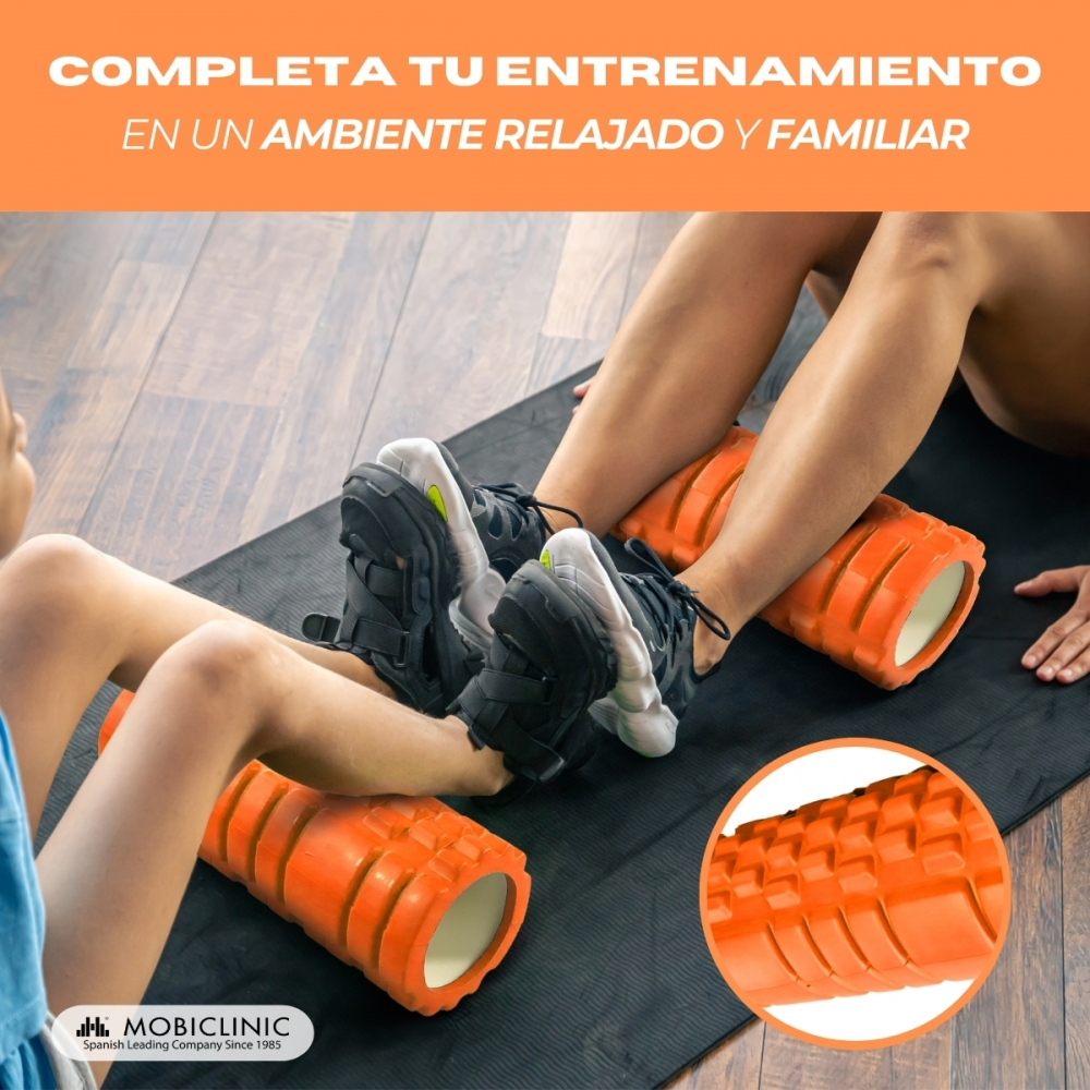 Dos personas usan rodillos de espuma naranjas sobre una esterilla para entrenar.