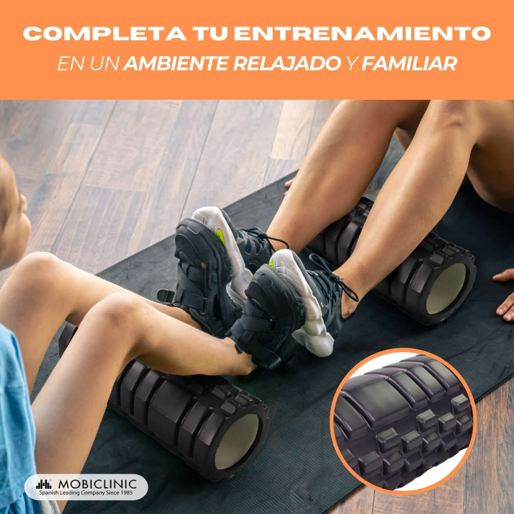 Dos personas usan rodillos de espuma negros para hacer ejercicio en una esterilla.