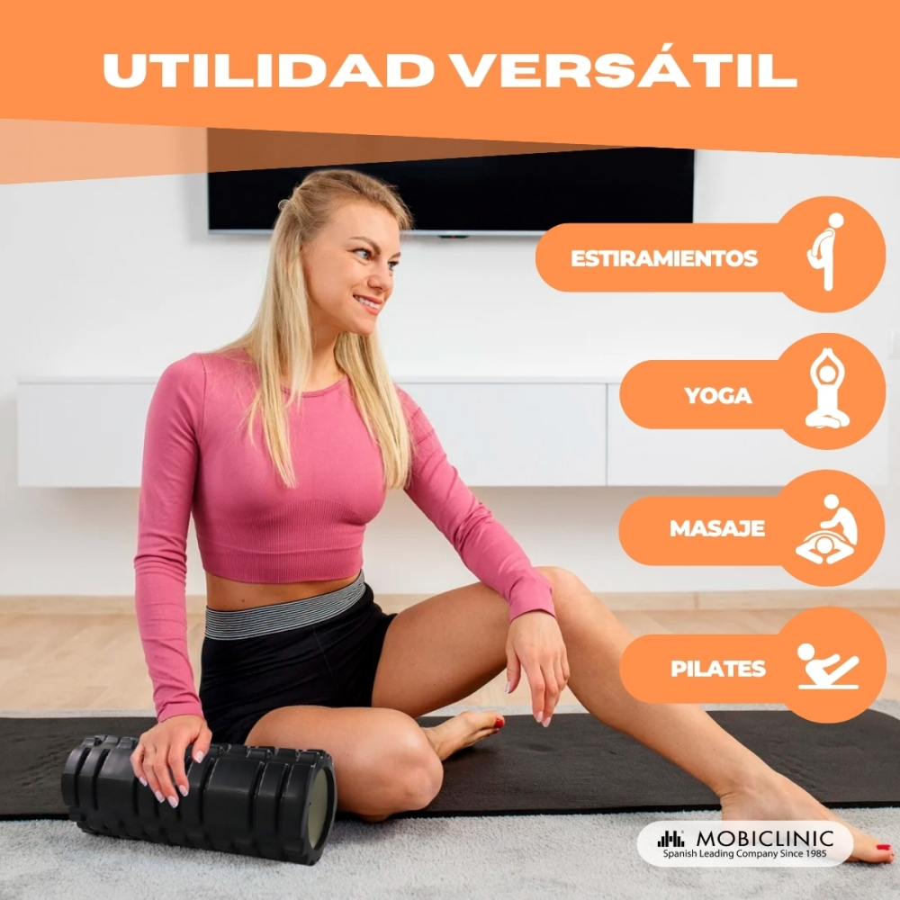 Una mujer sentada en una colchoneta con un rodillo de espuma al lado.