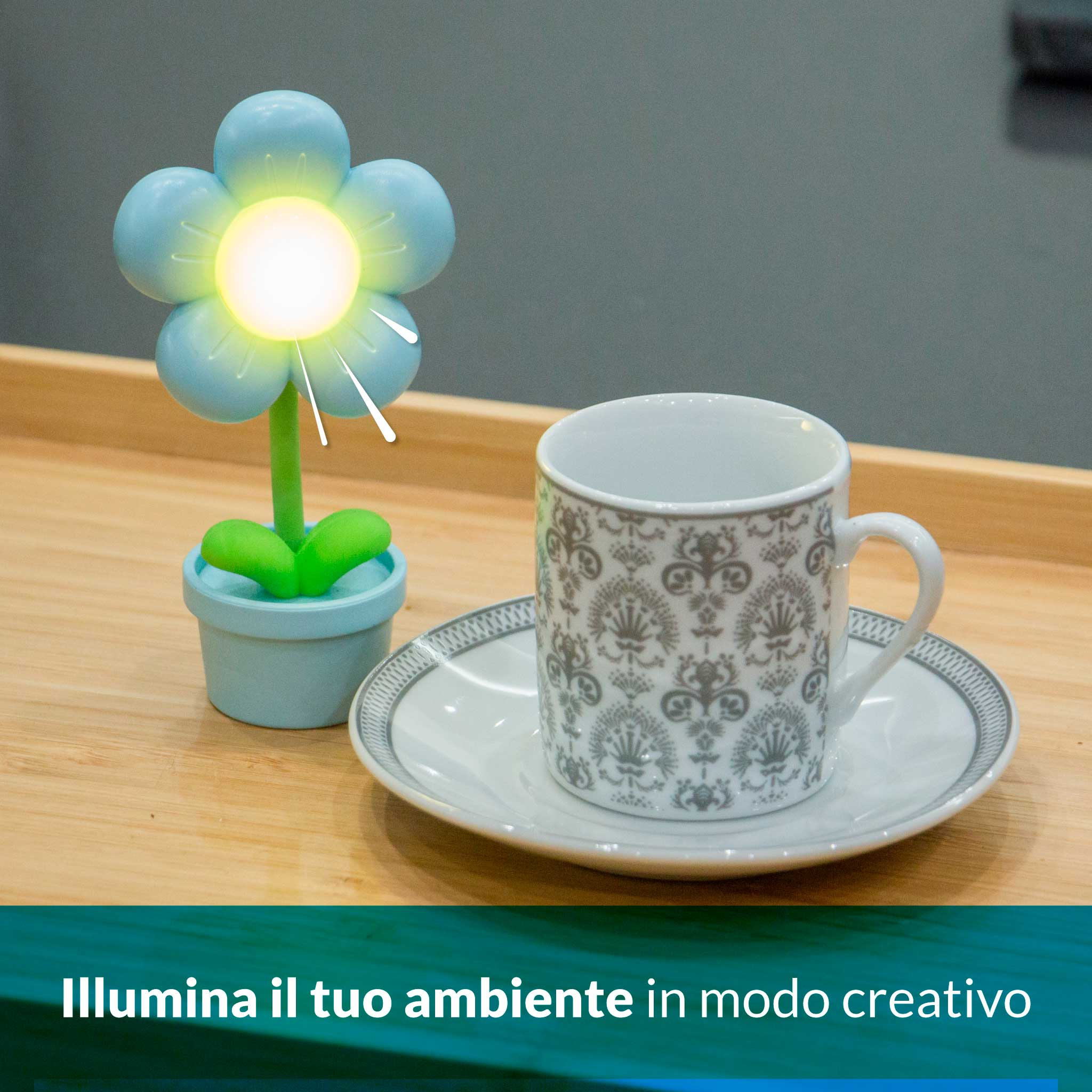 Una lampada a forma di fiore blu brilla accanto a una tazzina su un piattino.
