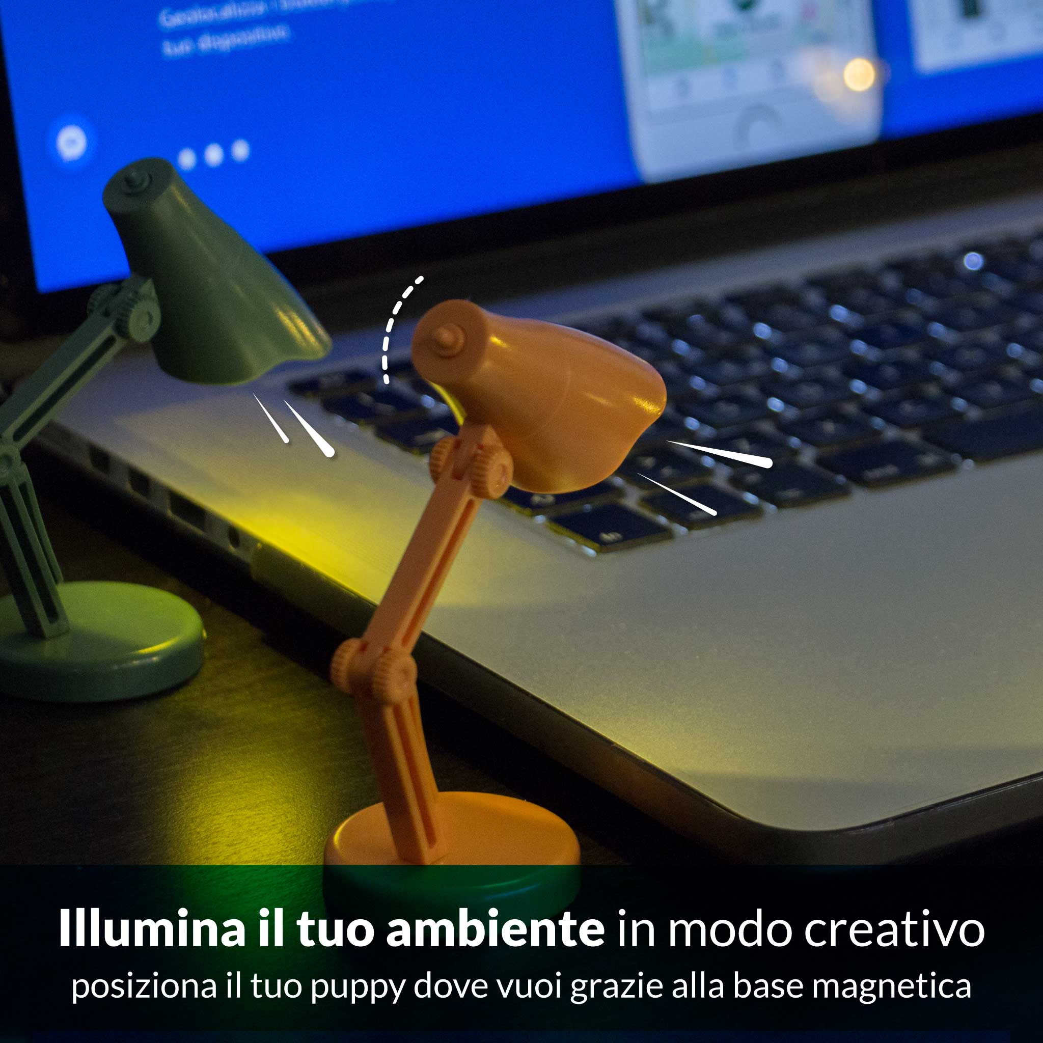 Due piccole lampade da scrivania, verde e arancione, illuminano una tastiera.