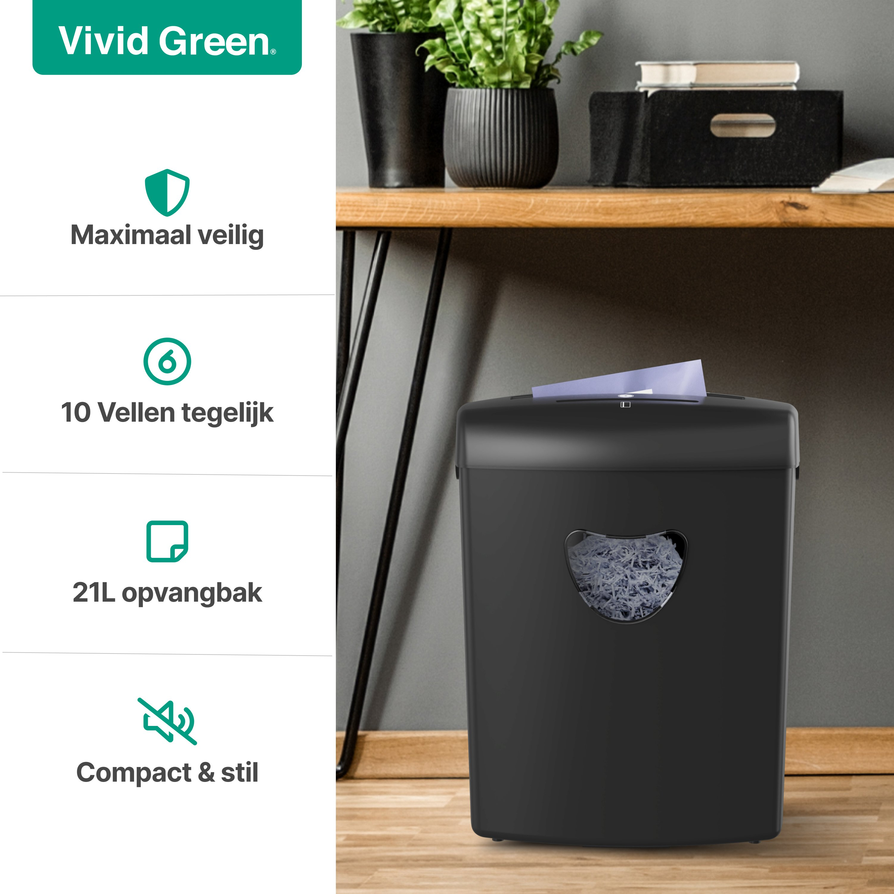 A black paper shredder sits on a wooden floor next to a desk.