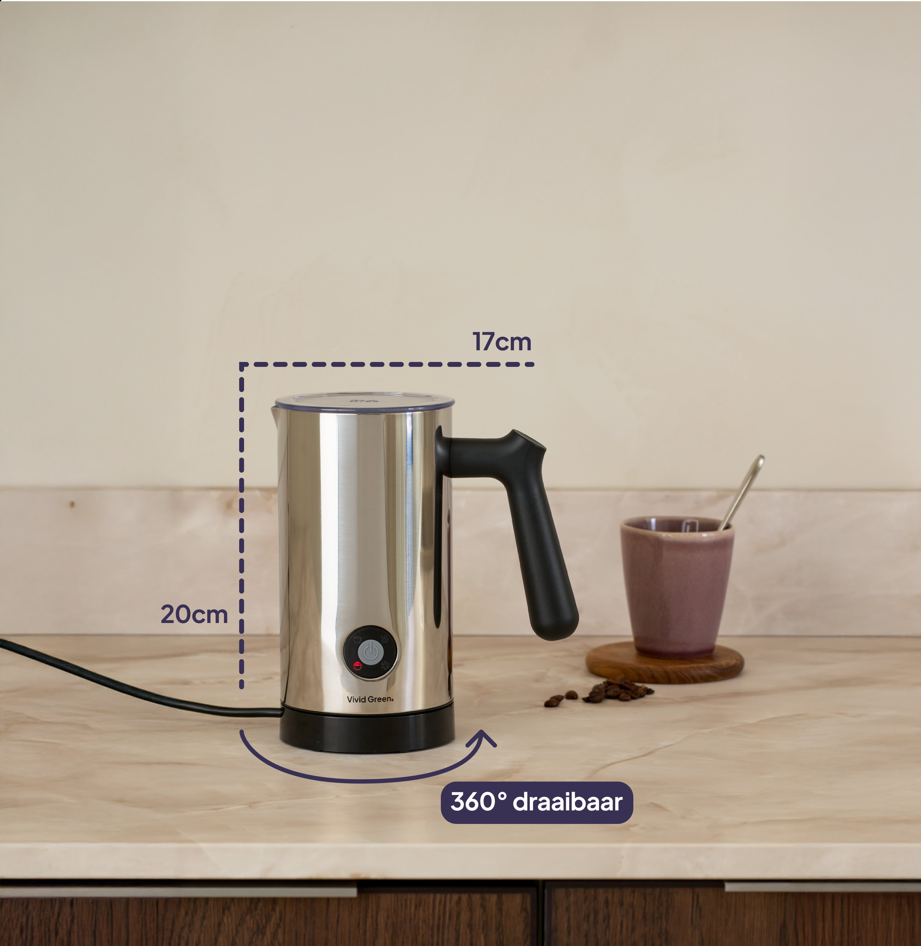 A silver milk frother with a black handle stands next to a cup.