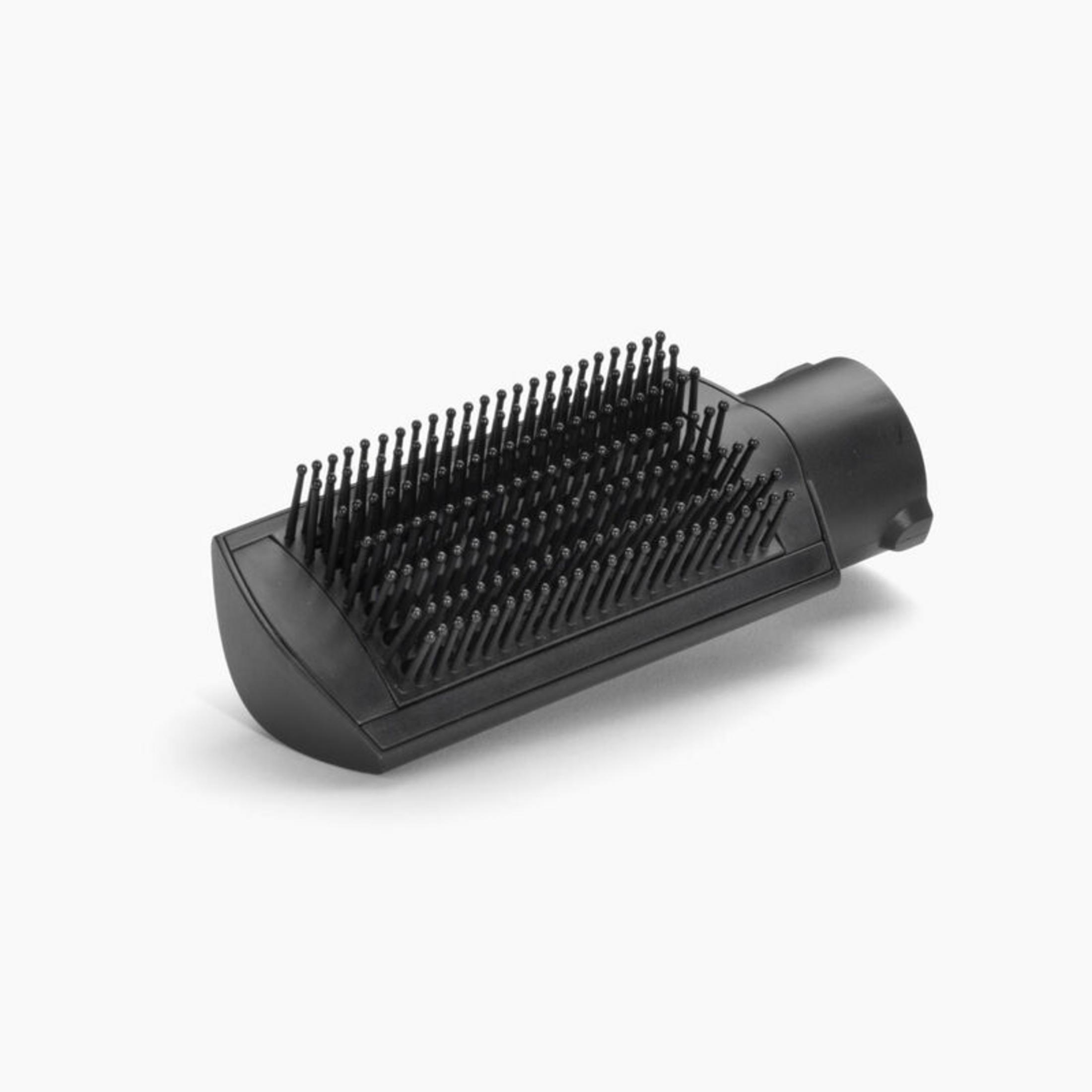 Un accessorio per spazzola per capelli nero con molte setole su sfondo bianco.