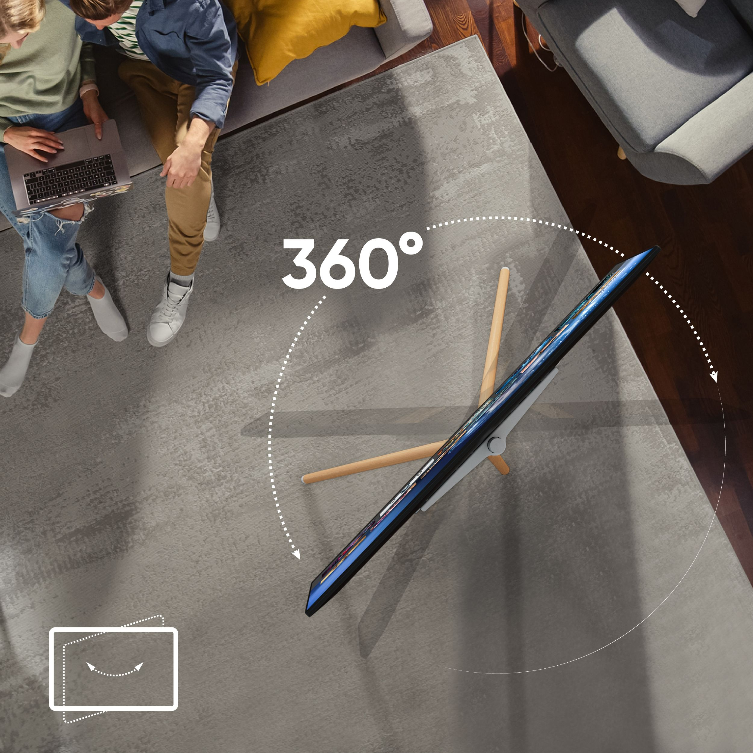 Dwie osoby siedzą na sofie. Telewizor się obraca.