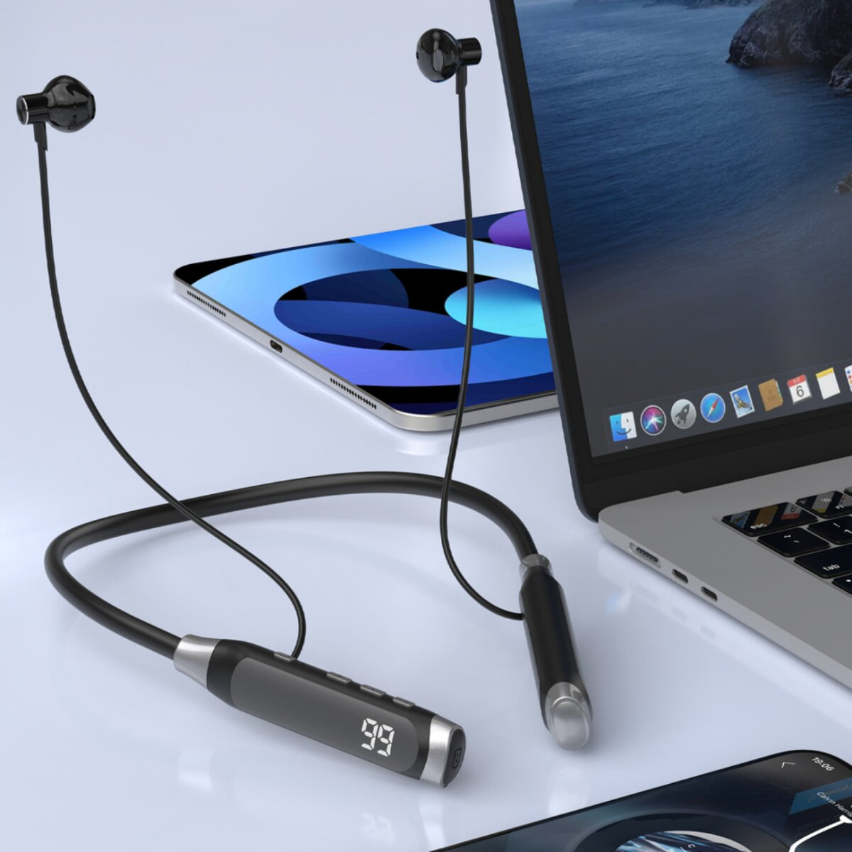 Auricolari da collo, tablet e laptop su superficie chiara.