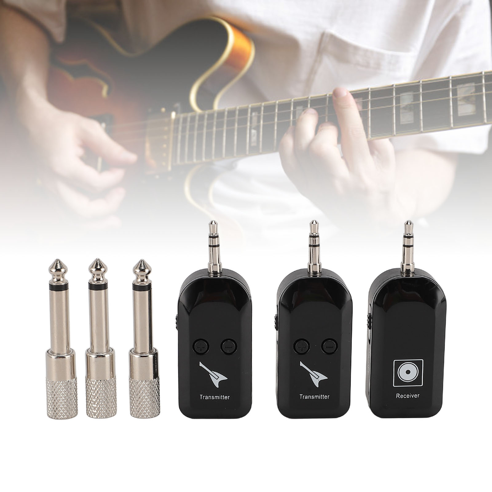 Drei schwarze Gitarren-Sender und ein Empfänger liegen vor einer Gitarre.