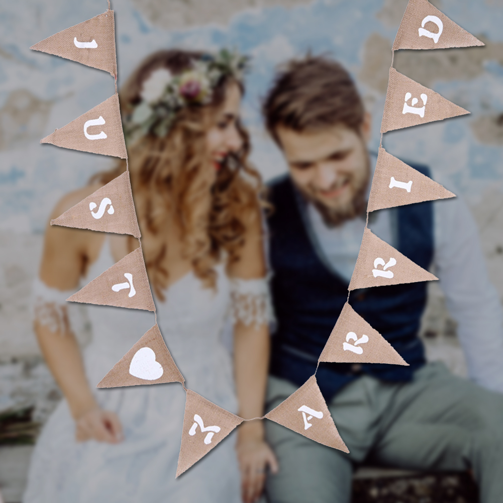 Hochzeitspaar vor einer Wand, mit einer "JUST MARRIED"-Girlande.